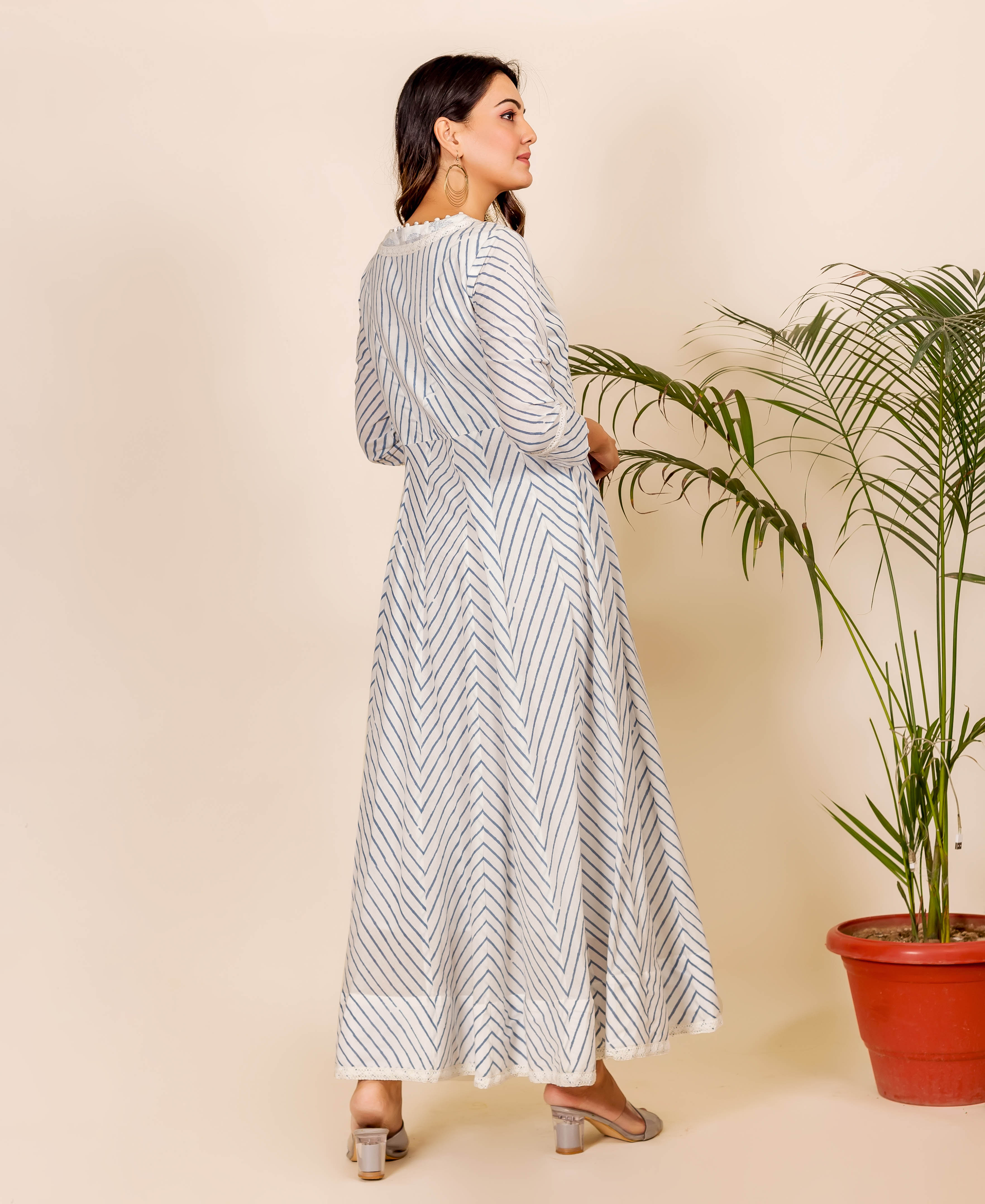 Model from back-side in white Anarkali dress with blue zig-zag stripe print.