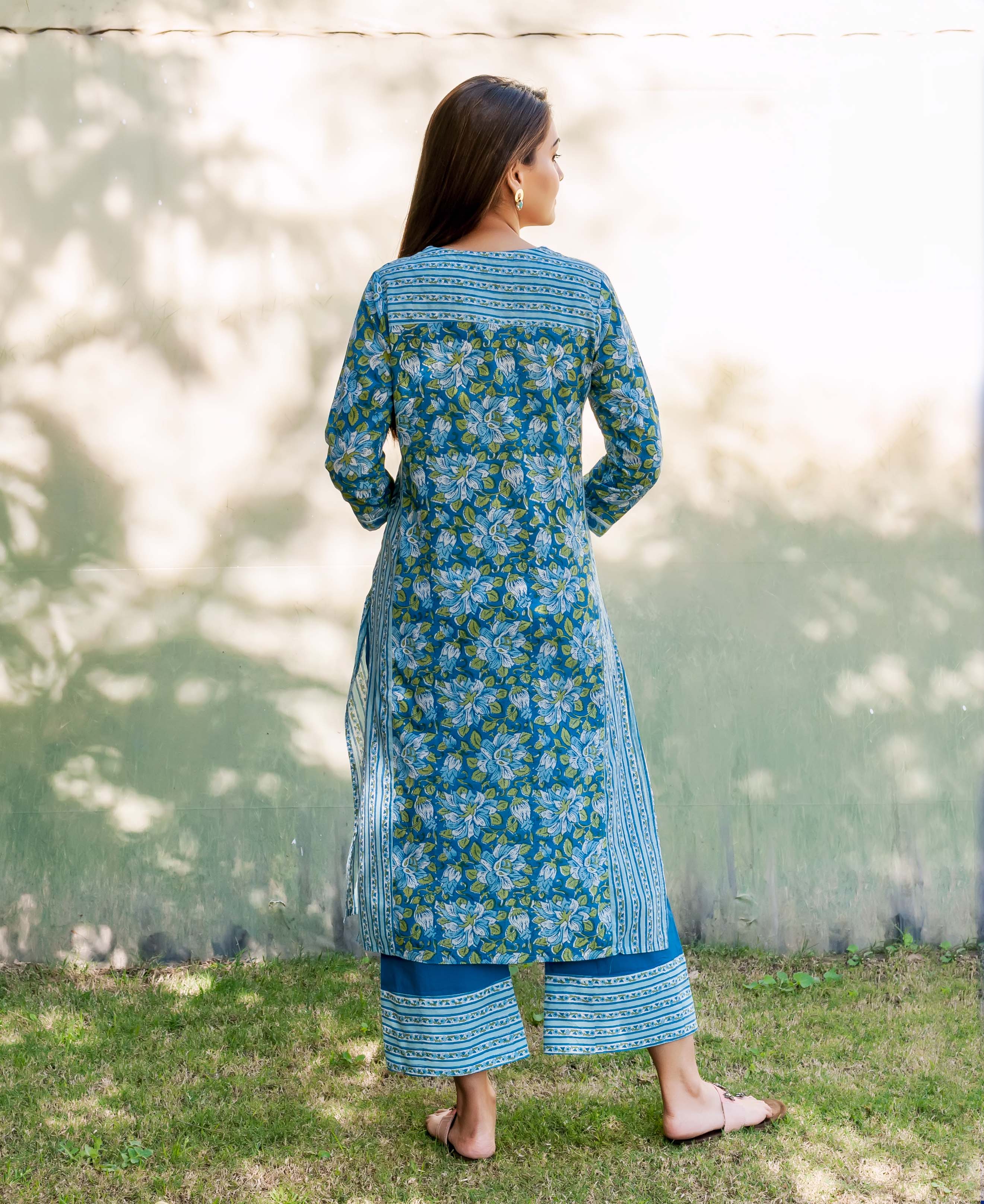 Back view of a woman in a sapphire hand block printed floral kurta and palazzo set.