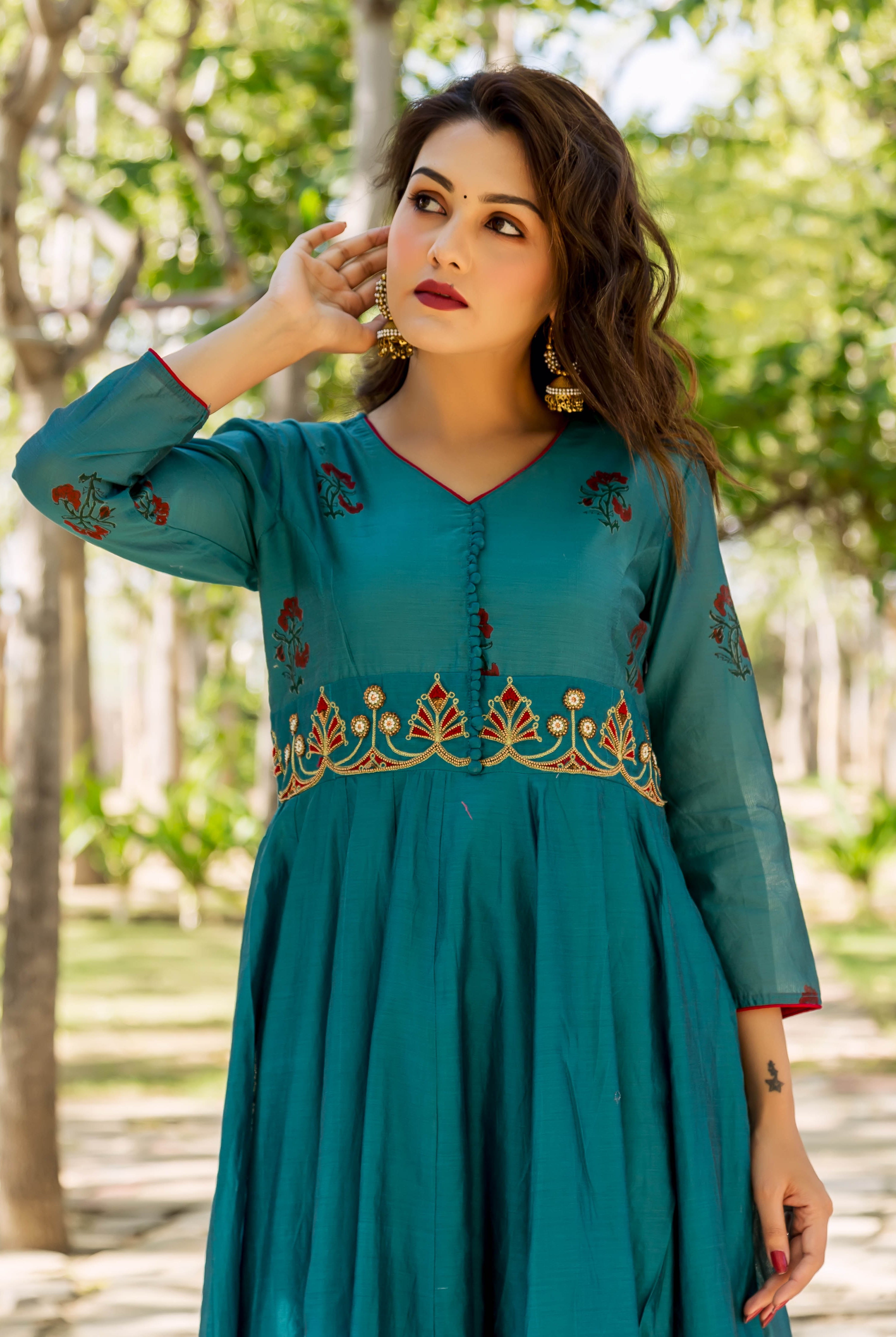 Front view model in teal kurta featuring hand embroidery on yoke and red block printed motifs.