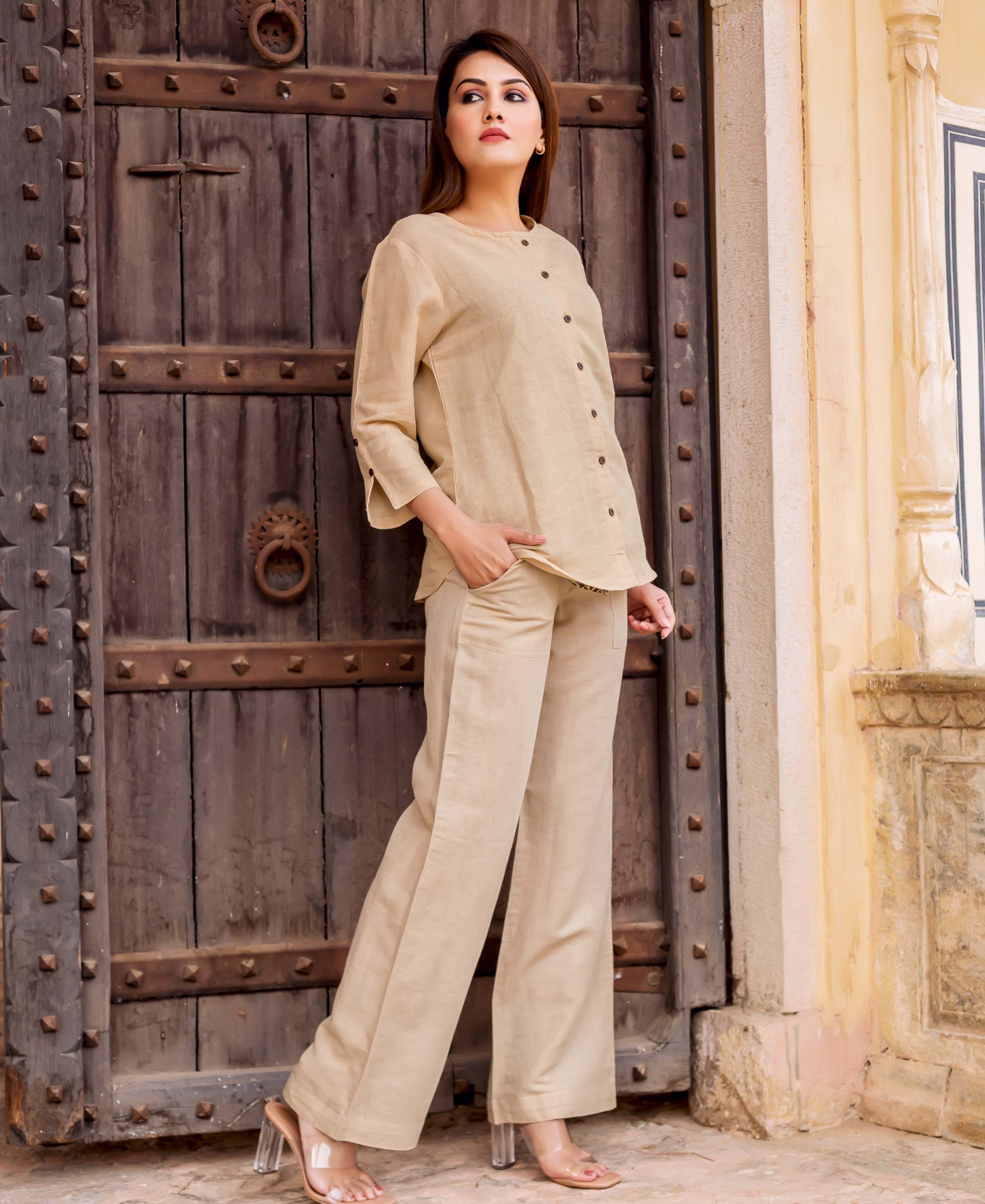 Model in a beige linen coordinated set, a buttoned top and wide-leg trousers.