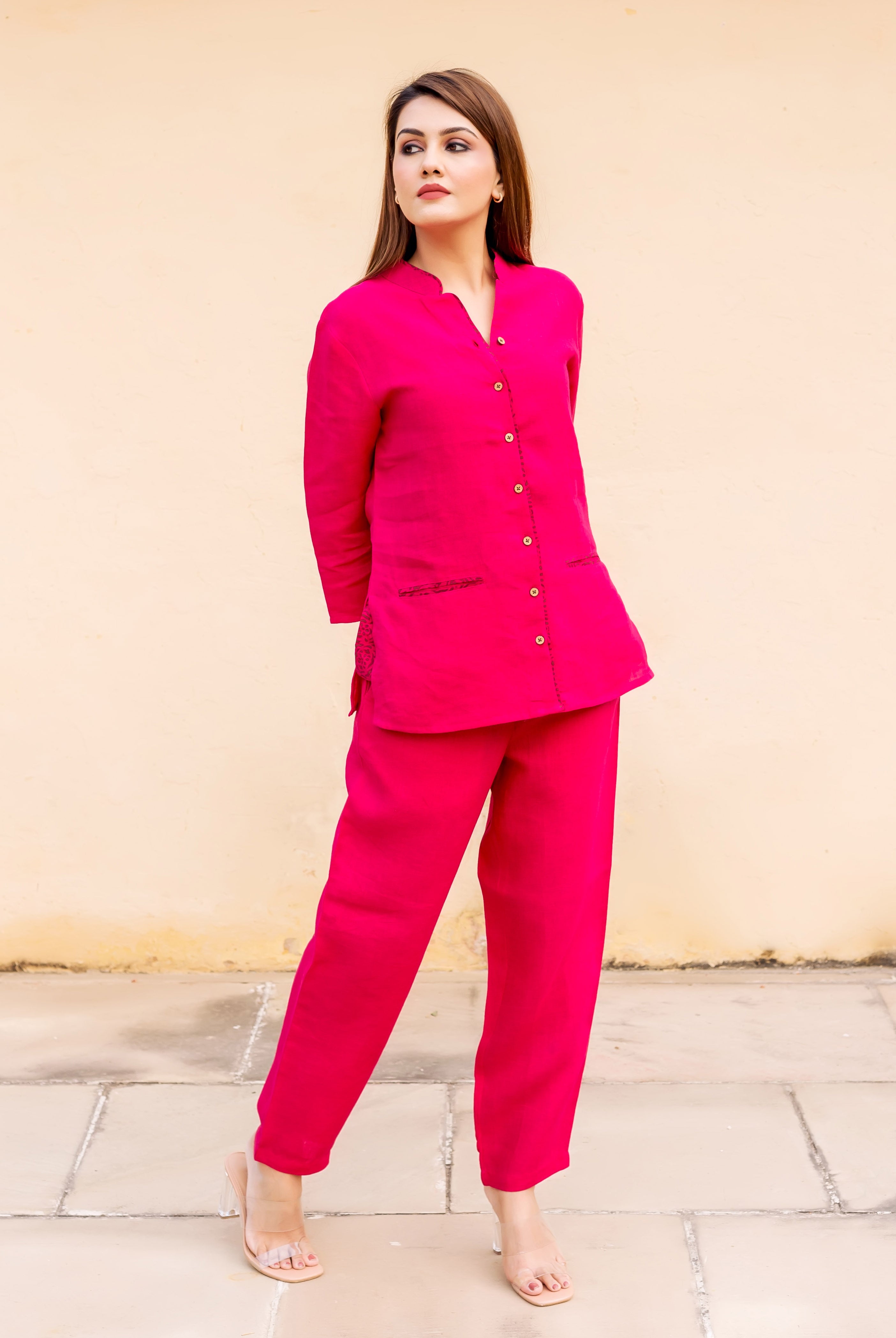 Model in full-length ruby pink linen power suit with subtle ethnic hand-block details.