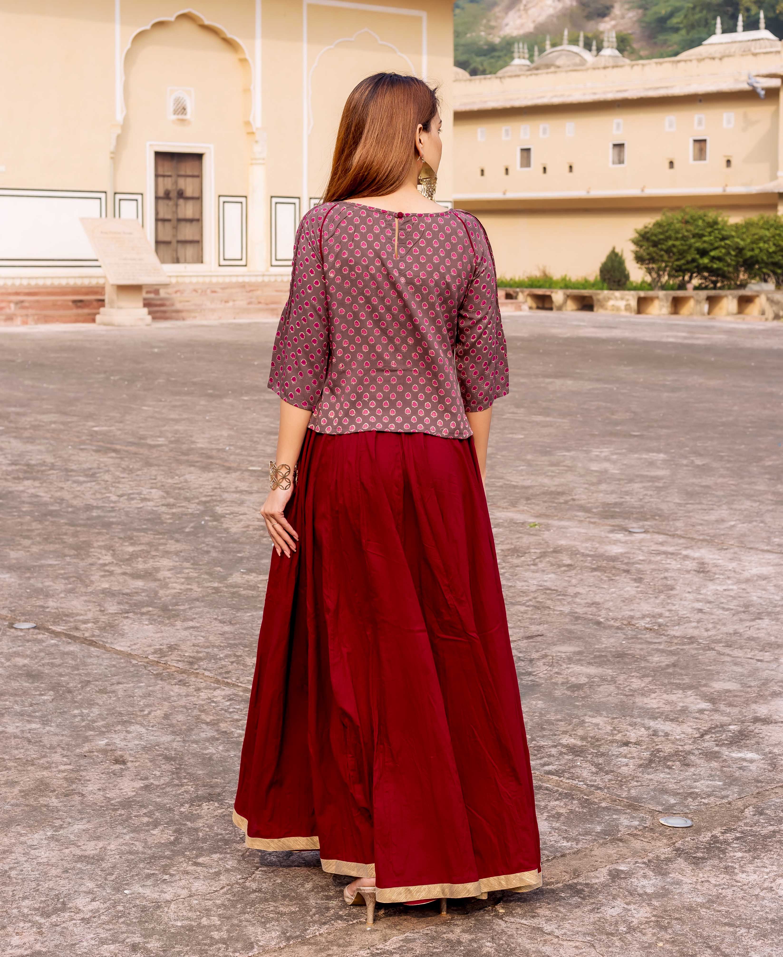 Rear view of woman in brown short top with small maroon circular print.