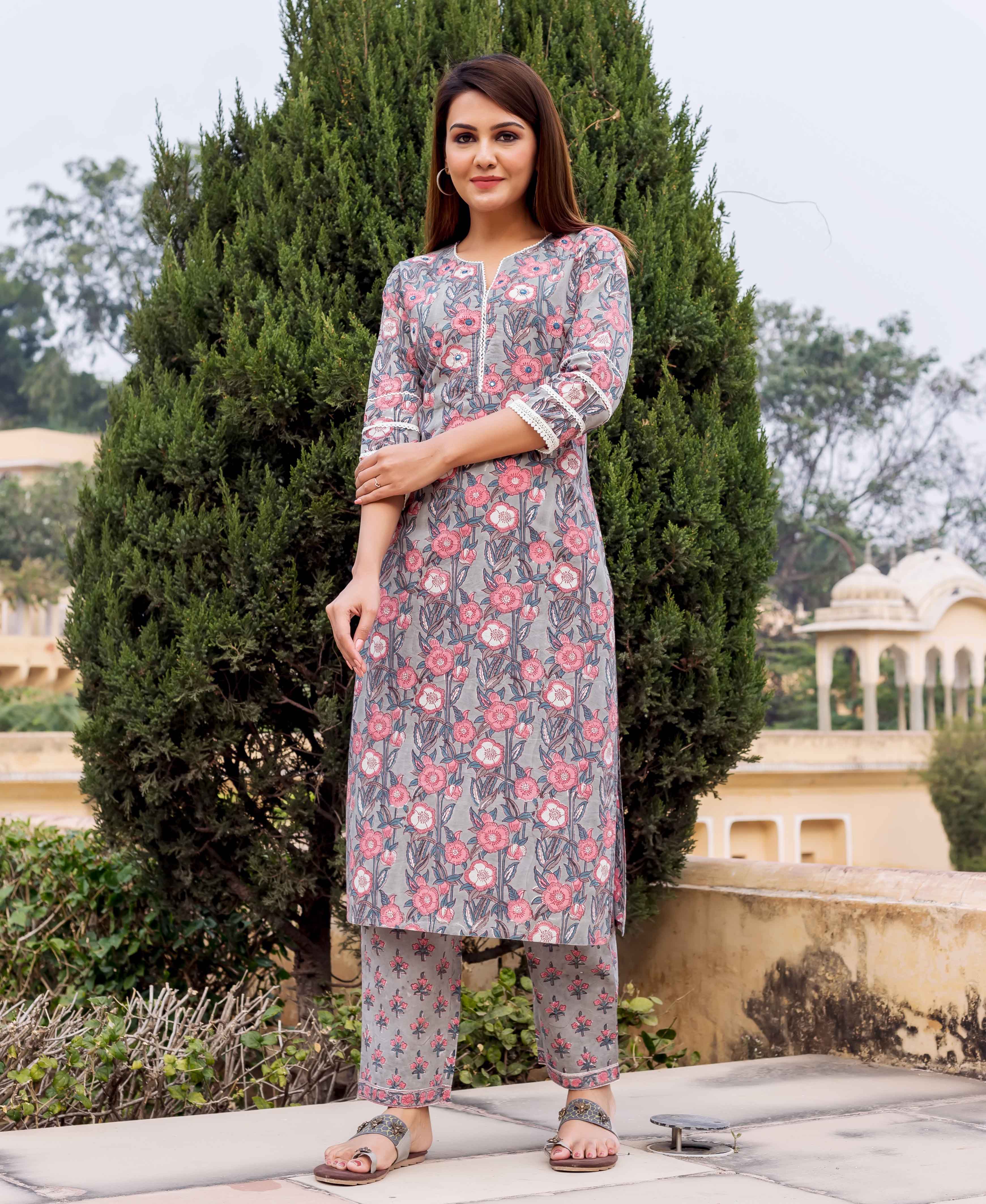A model wearing a grey and pink hand block printed kurta with floral patterns.