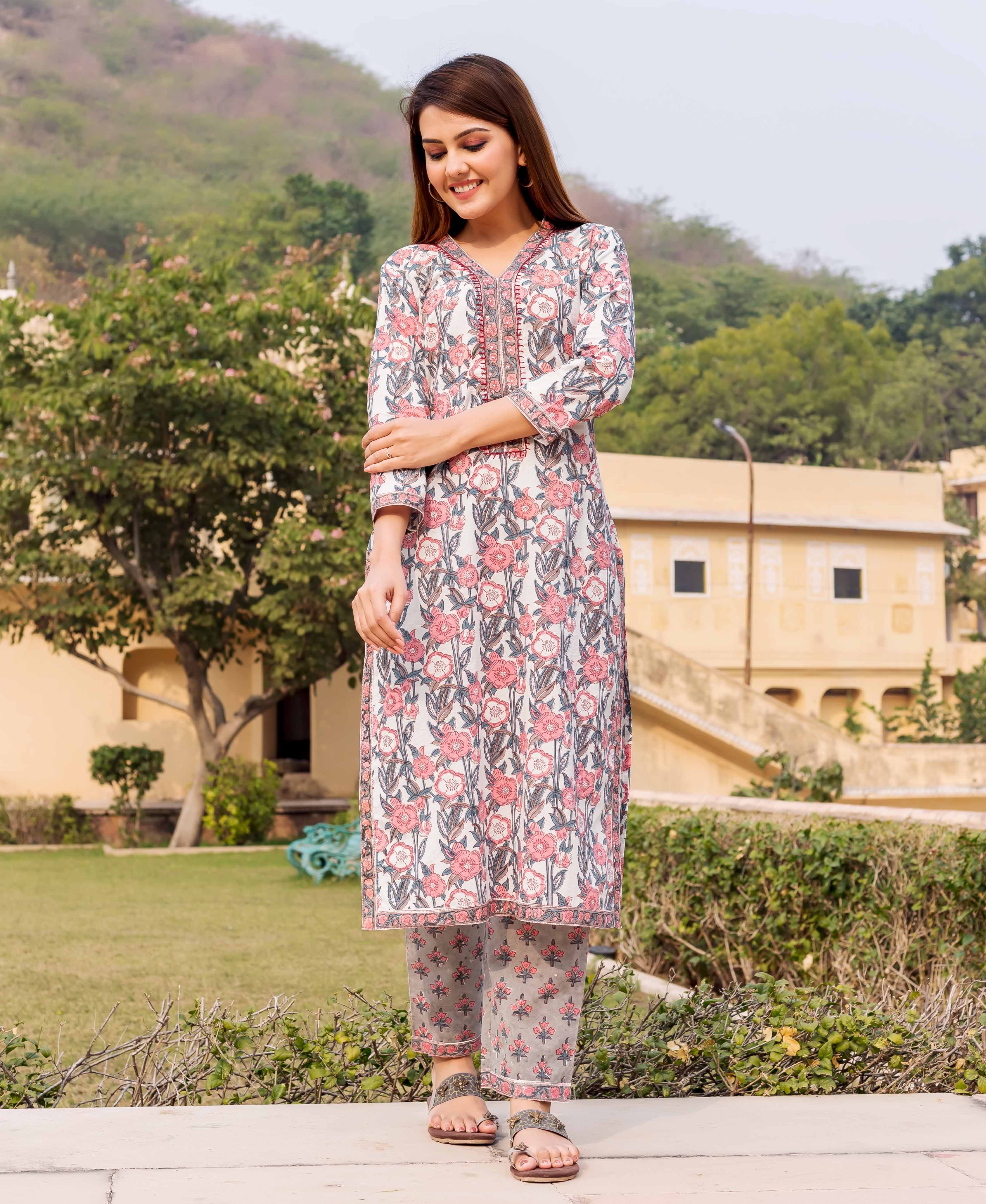 Smiling model wears an off-white and pink floral hand block printed ethnic kurta set.