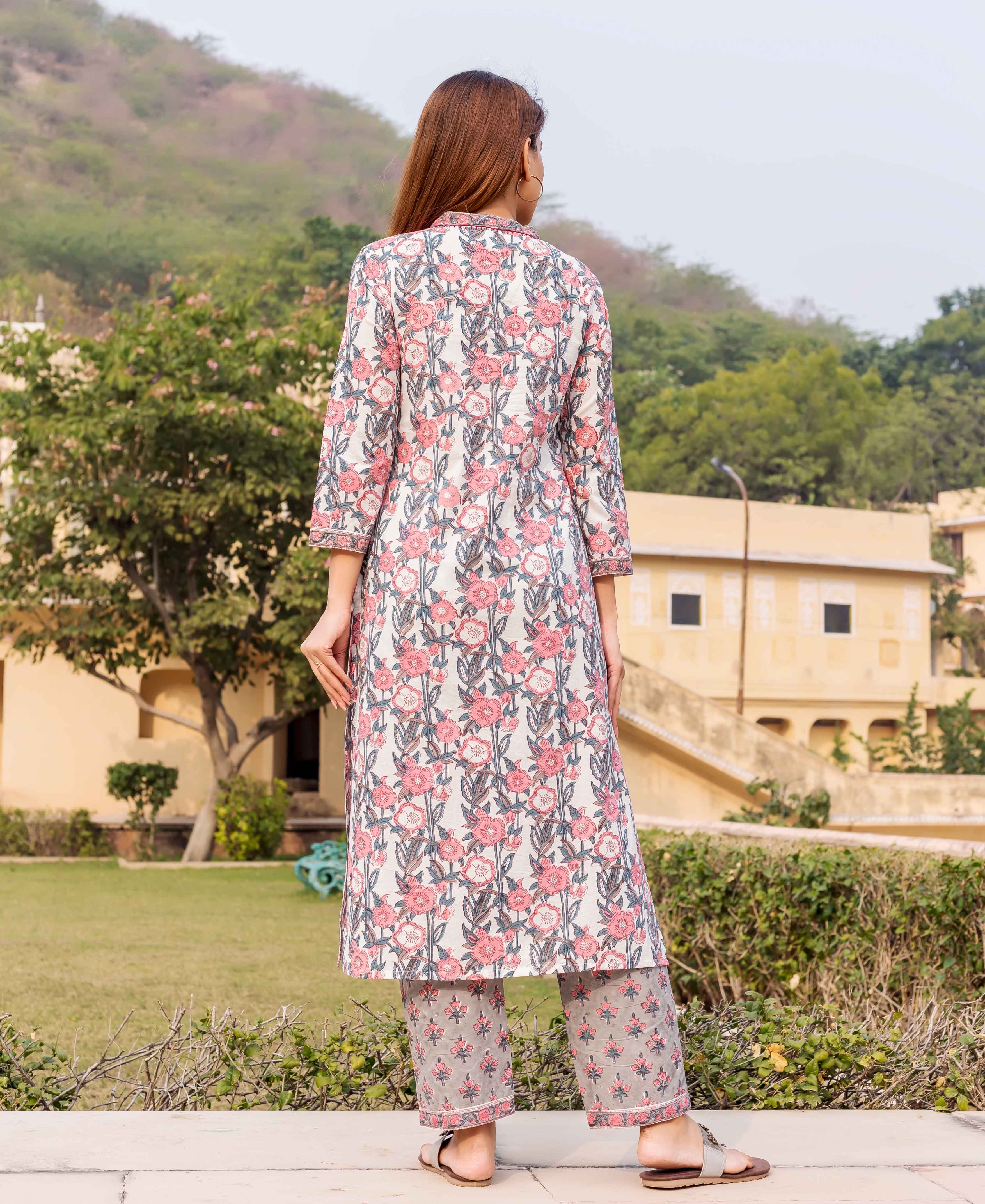 Model from back wearing white and pink hand-block printed floral kurta with matching grey pants.