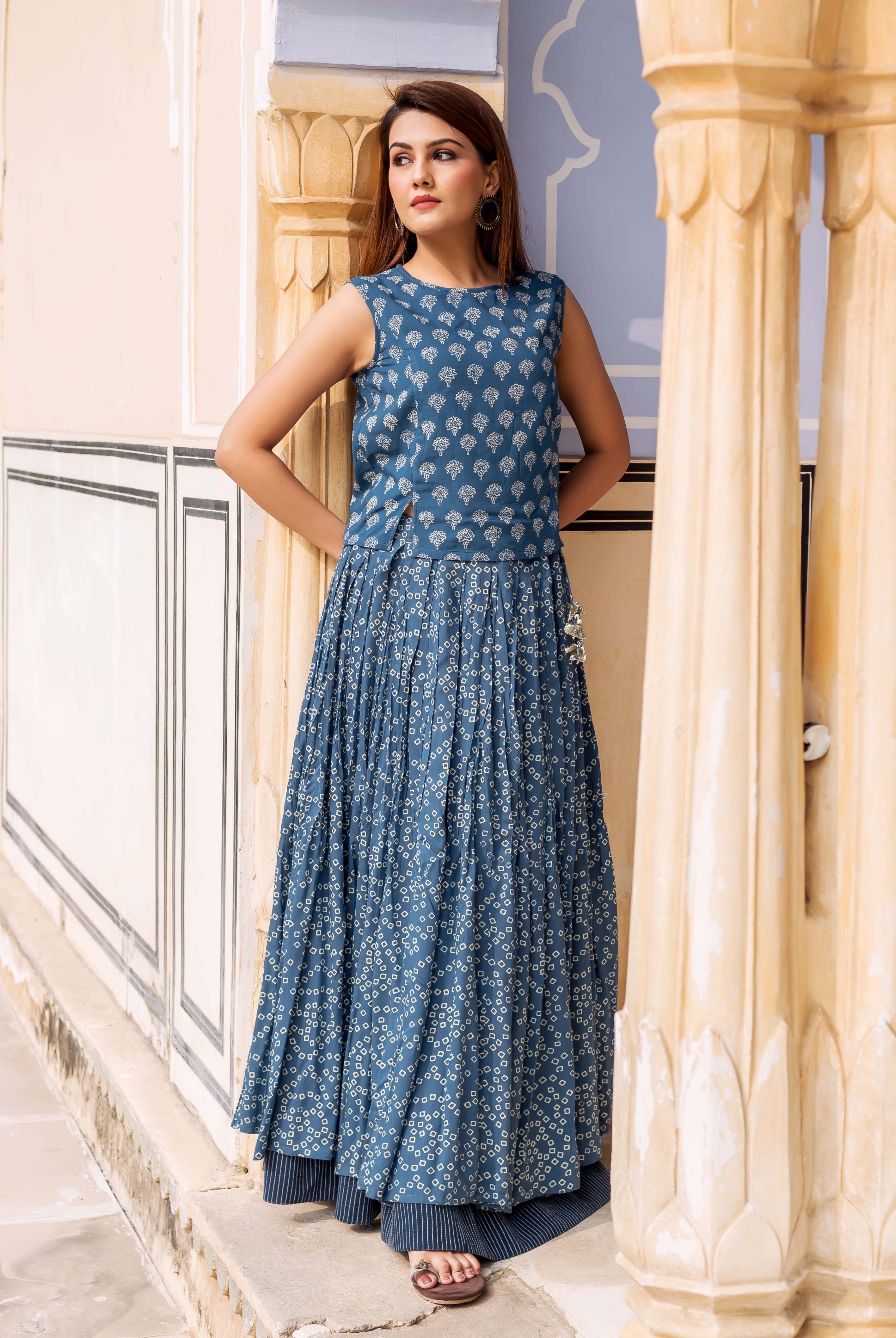 Front view of model in an indigo blue sleeveless block-printed top and pleated skirt.