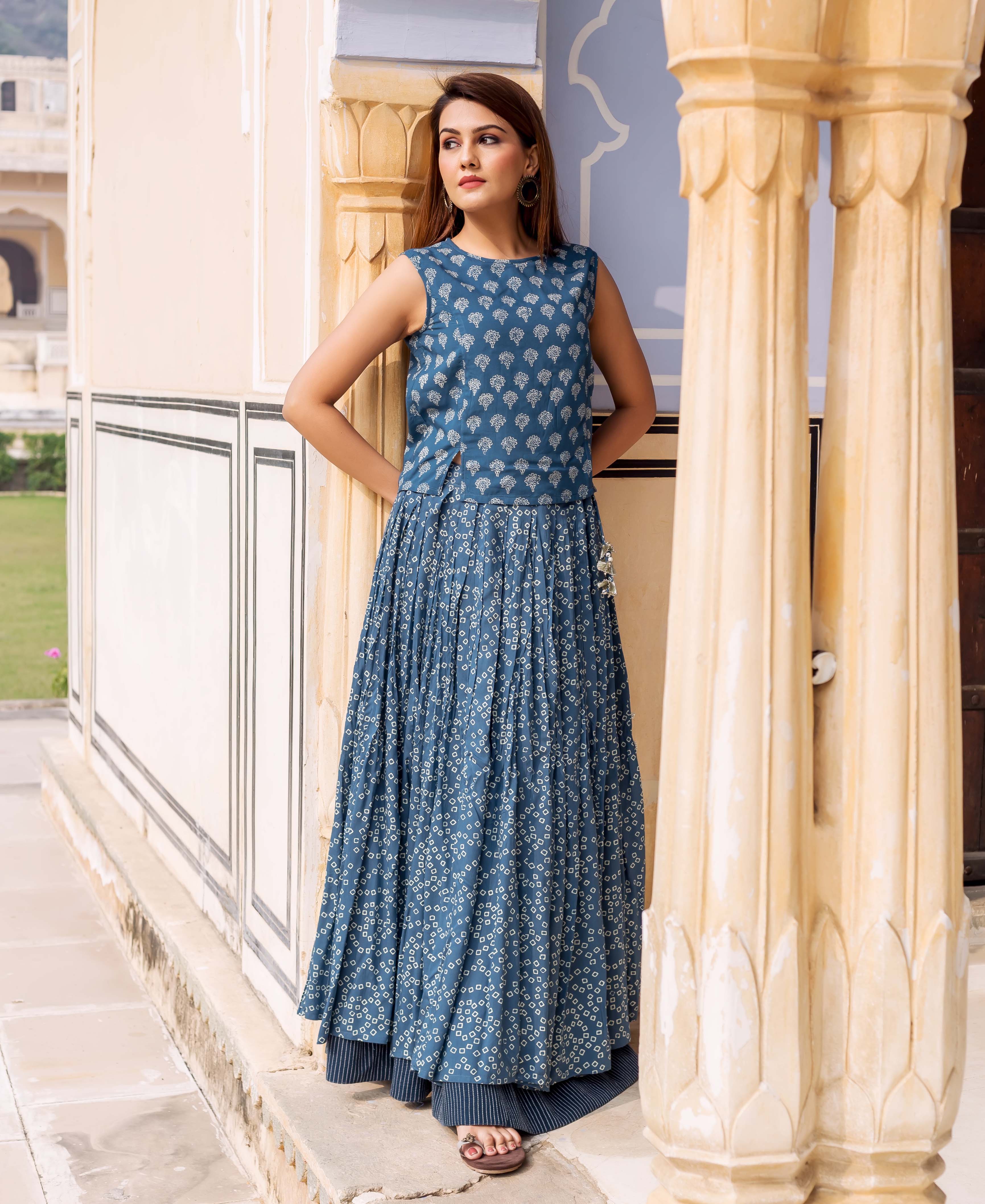 Front view of model in an indigo blue sleeveless block-printed top and pleated skirt.