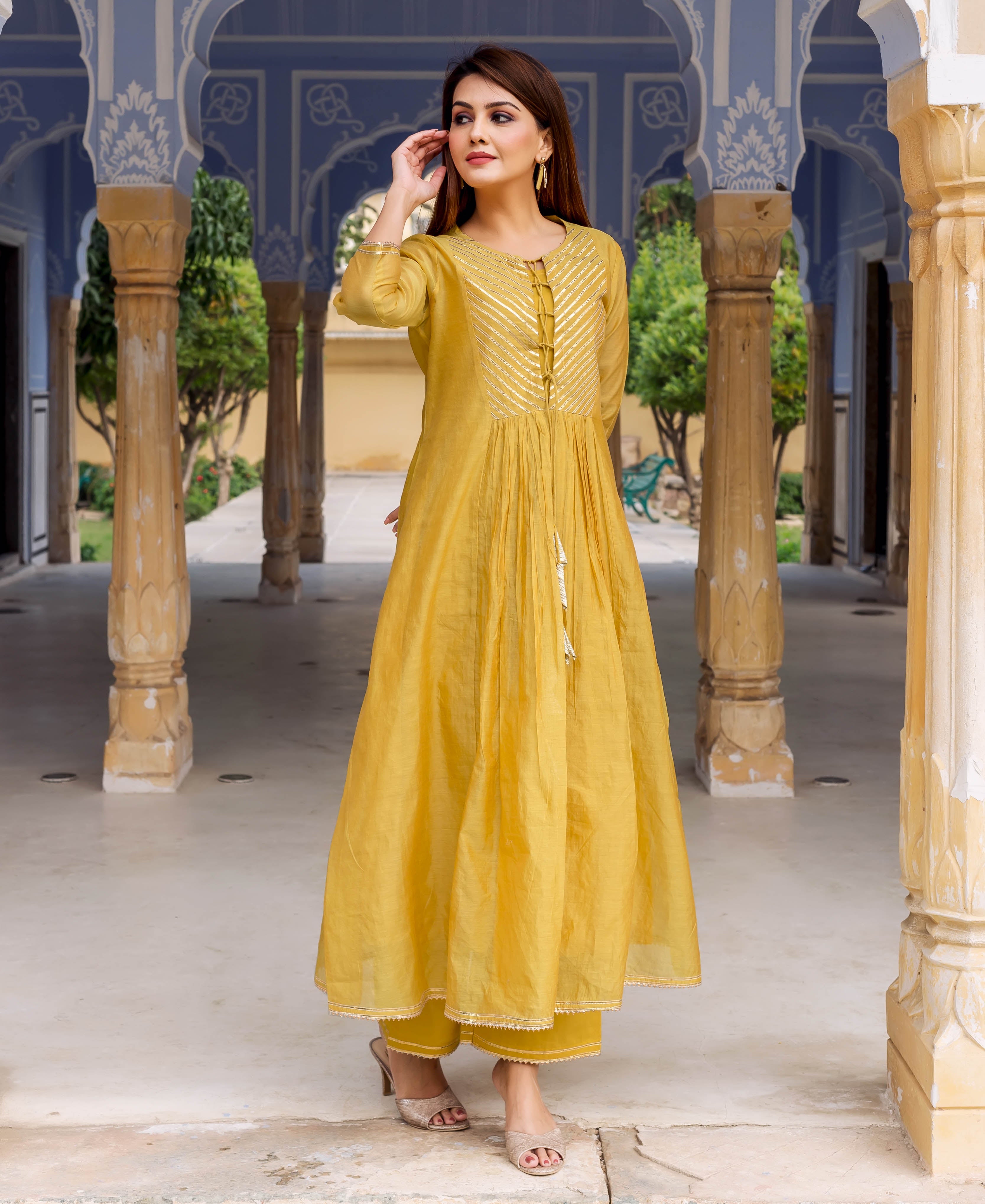 Front full look of a model in a honey yellow kurta with golden gotta work on the yoke.