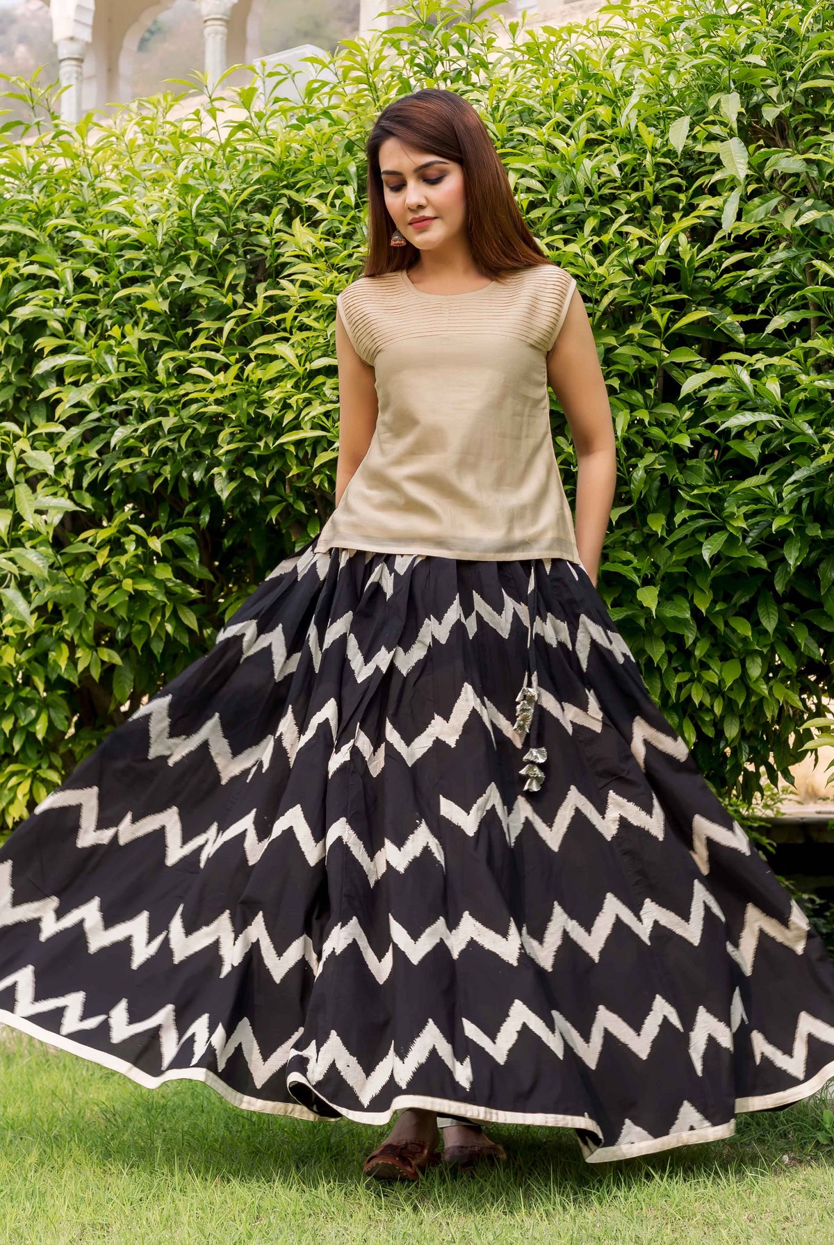 Model in beige chanderi sleeveless top and black-and-white chevron print skirt.