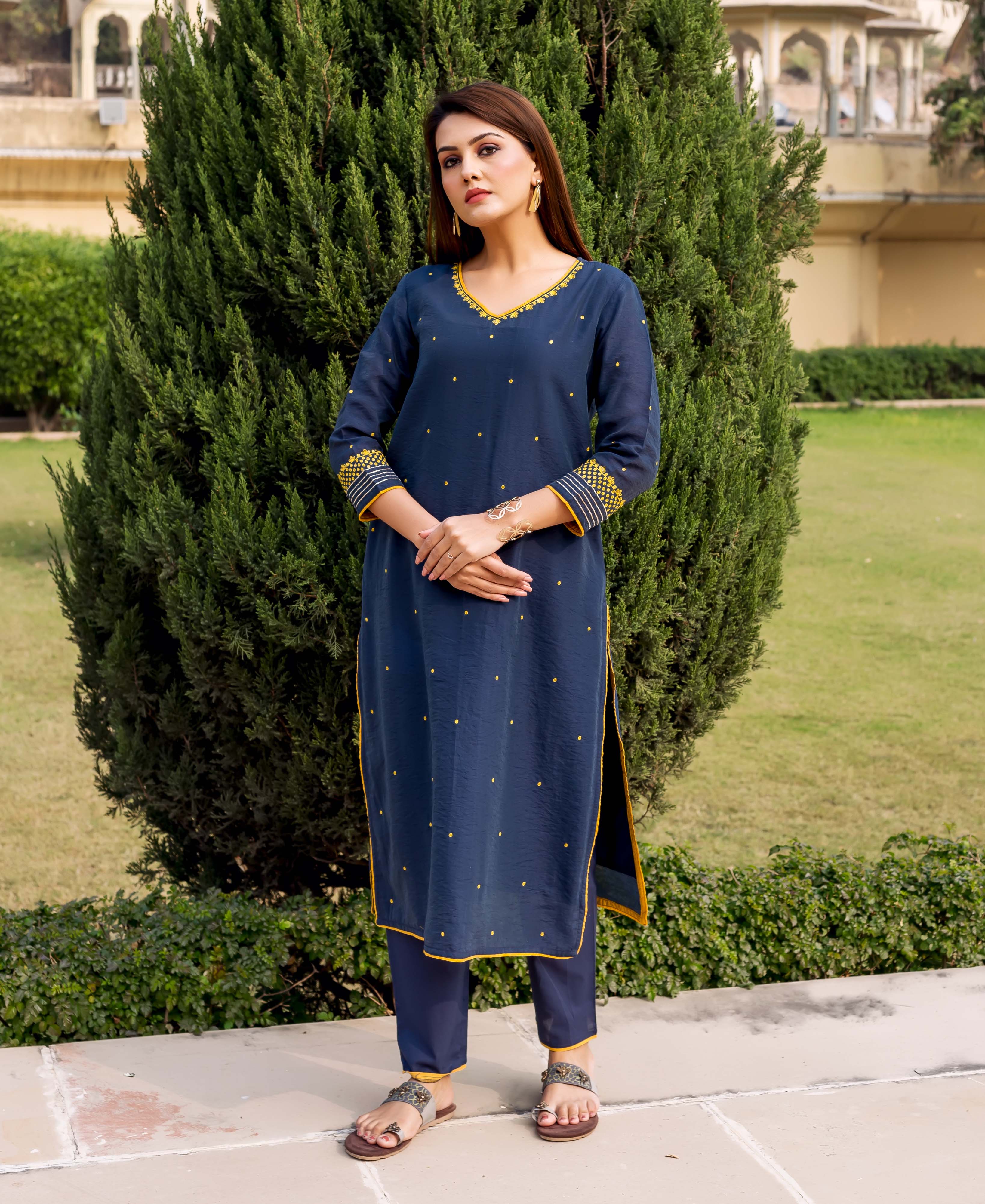 Navy blue kurta with yellow embroidered details and small yellow dots, paired with matching pants.