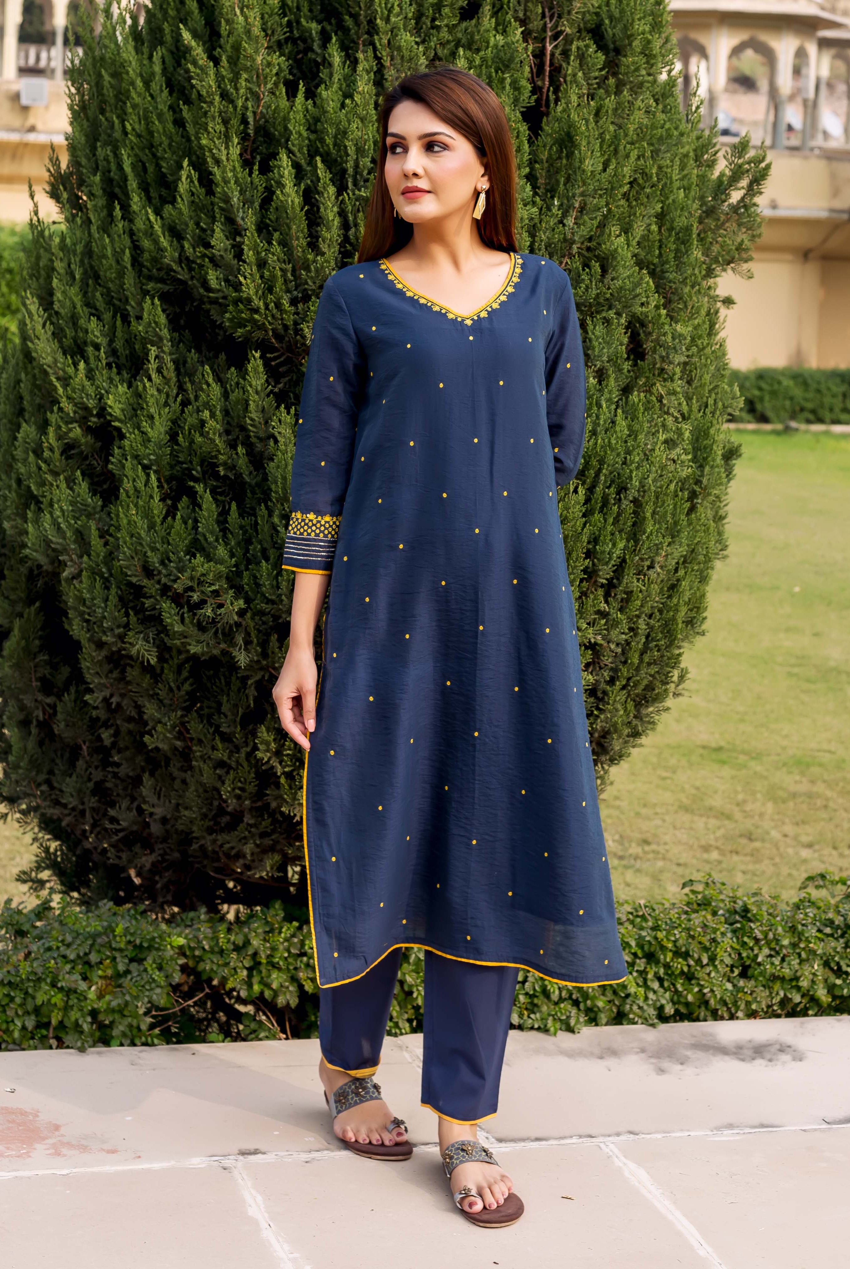 Navy blue embroidered kurta with yellow accents on a model outdoors in natural setting.
