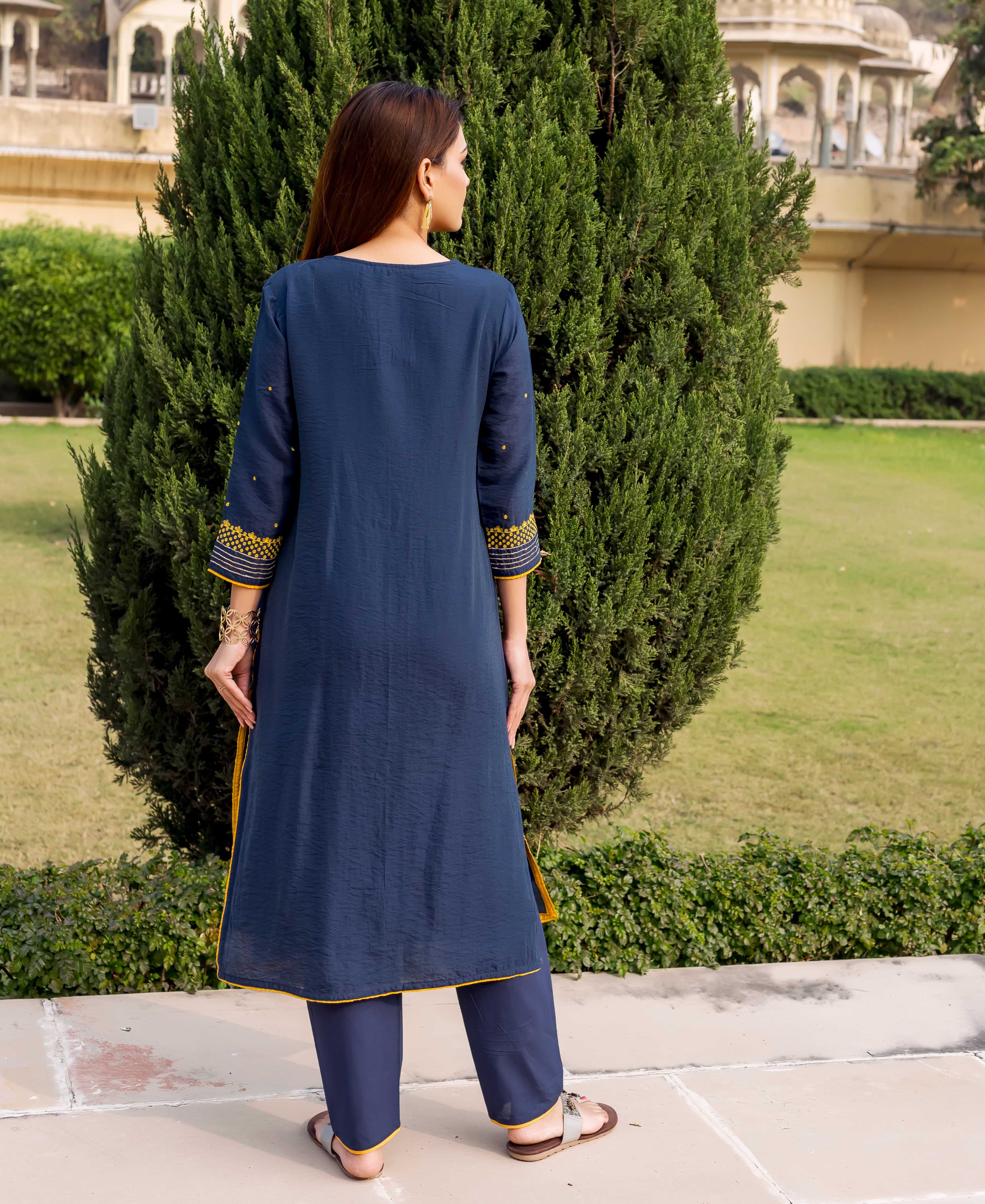 Model wearing navy blue kurta set, back view, with yellow embroidery and trim details.