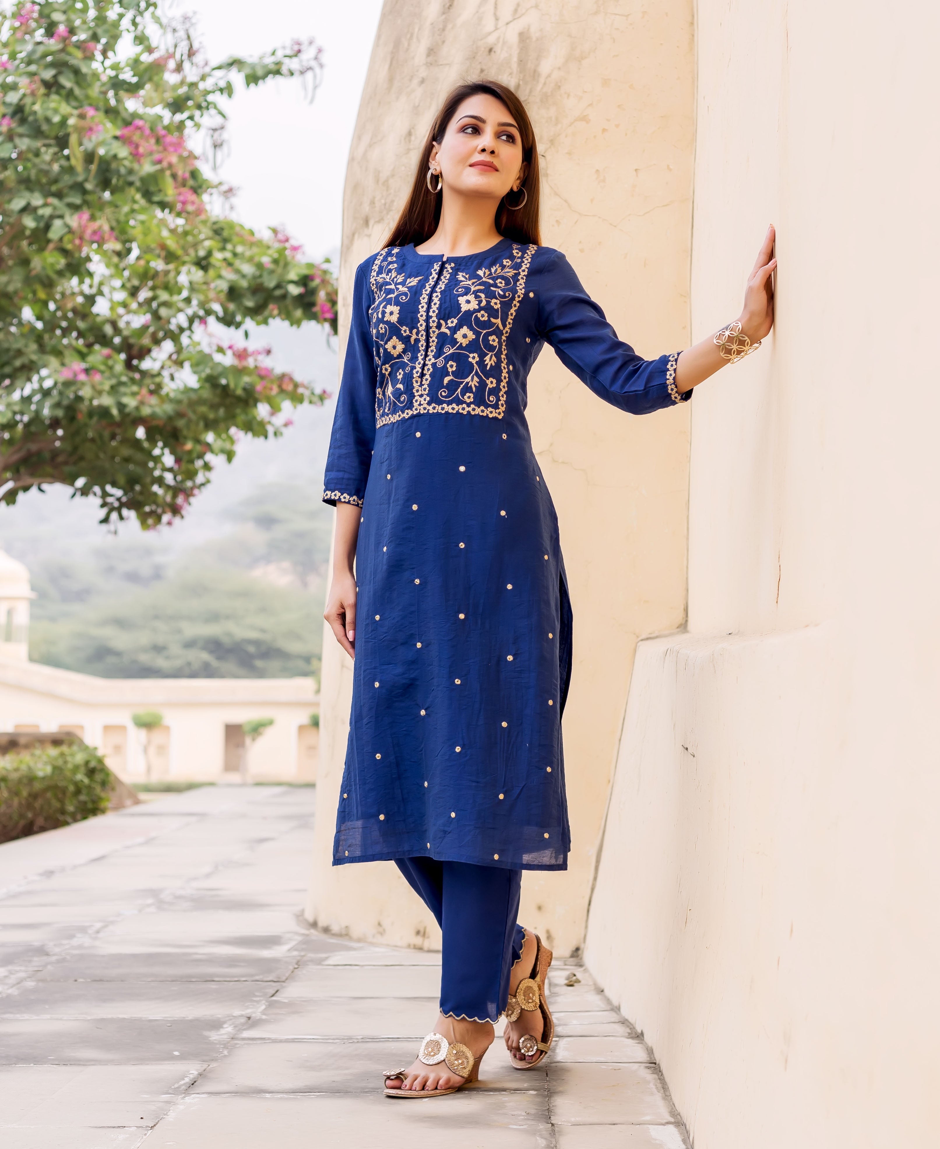 Full-length shot of a model wearing a midnight blue kurta with golden hand embroidery and matching pants.