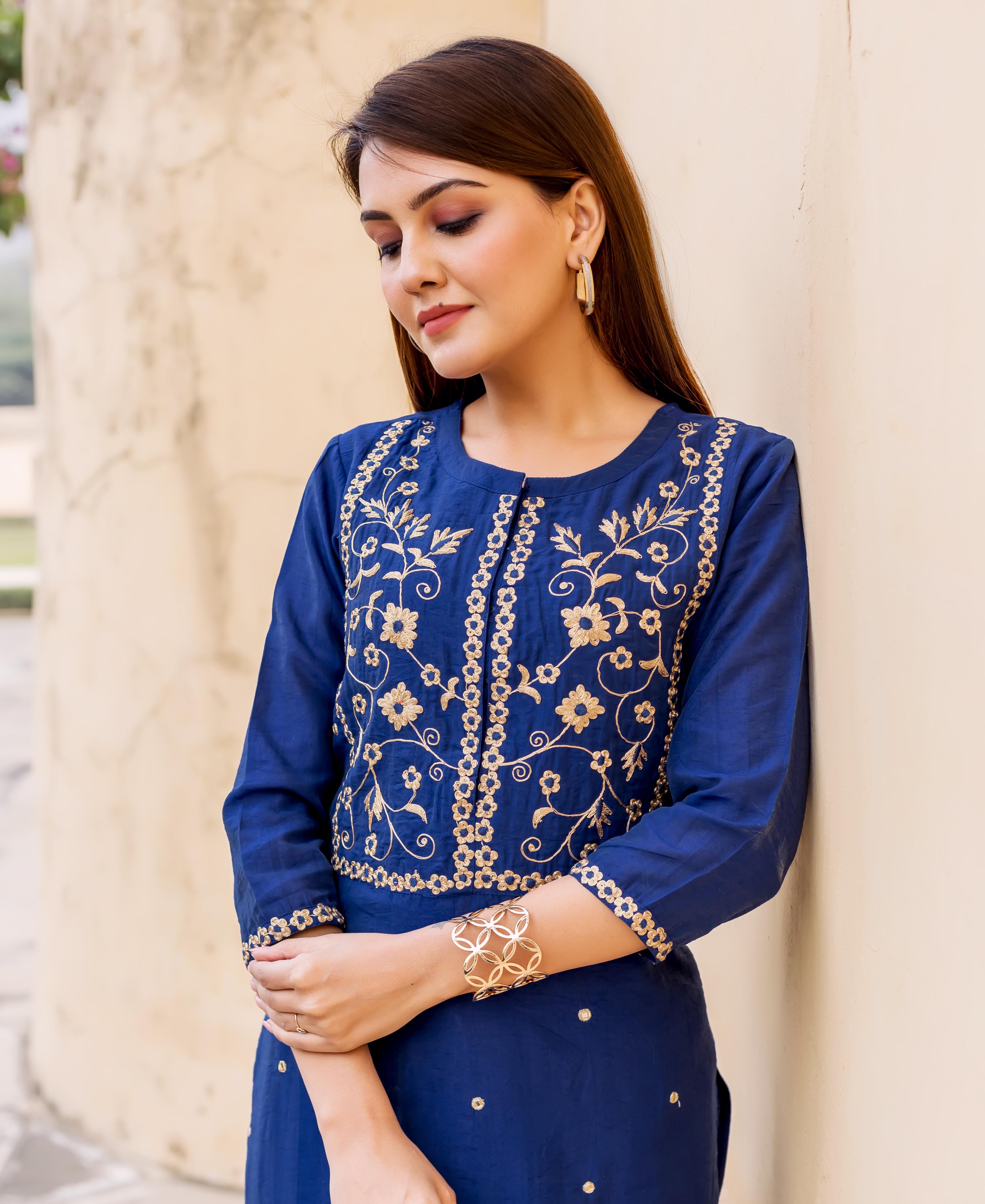 Model wears midnight blue hand-embroidered kurta with golden floral patterns on bodice.