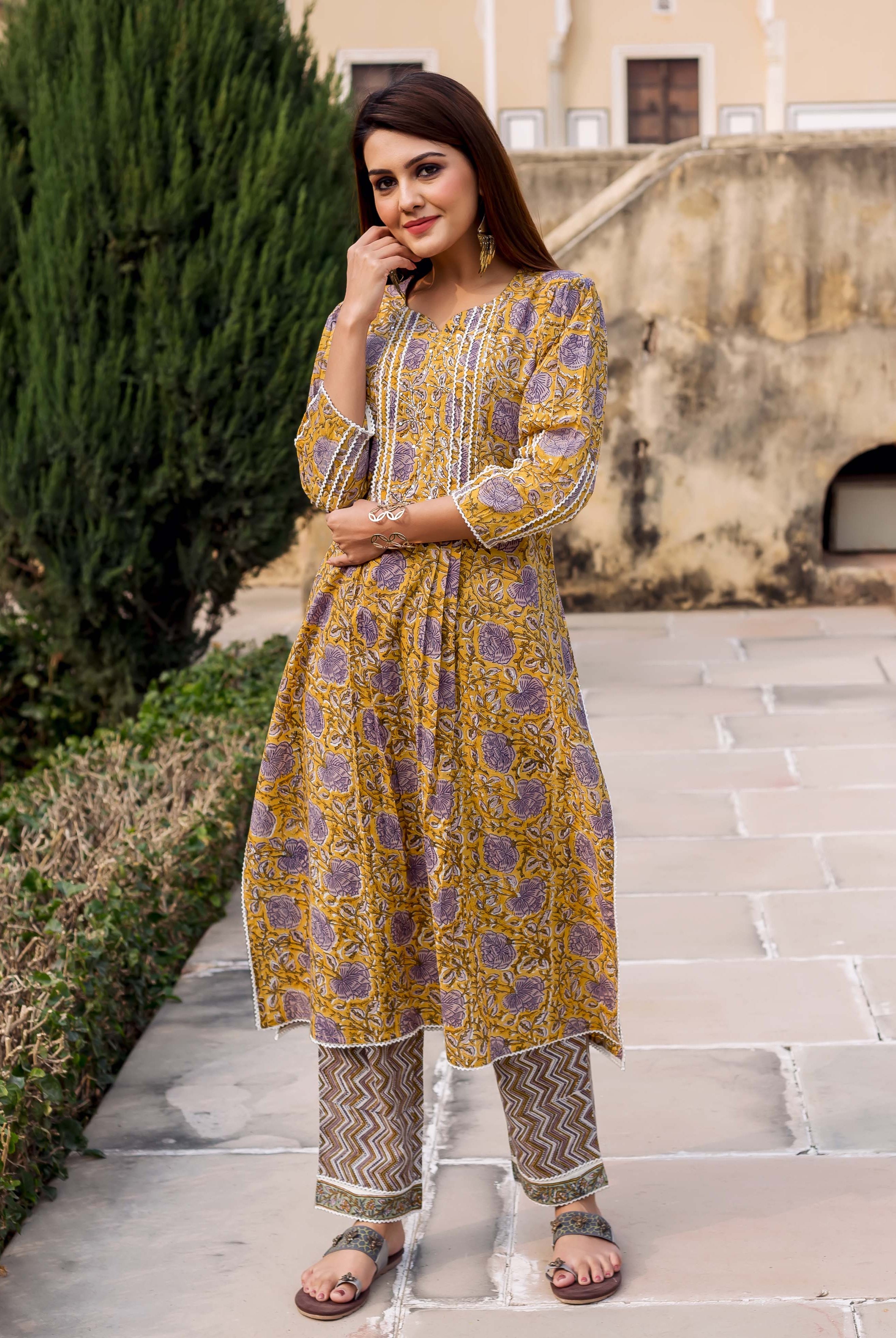 Front view model in yellow hand-block printed kurta with purple florals and patterned pants.