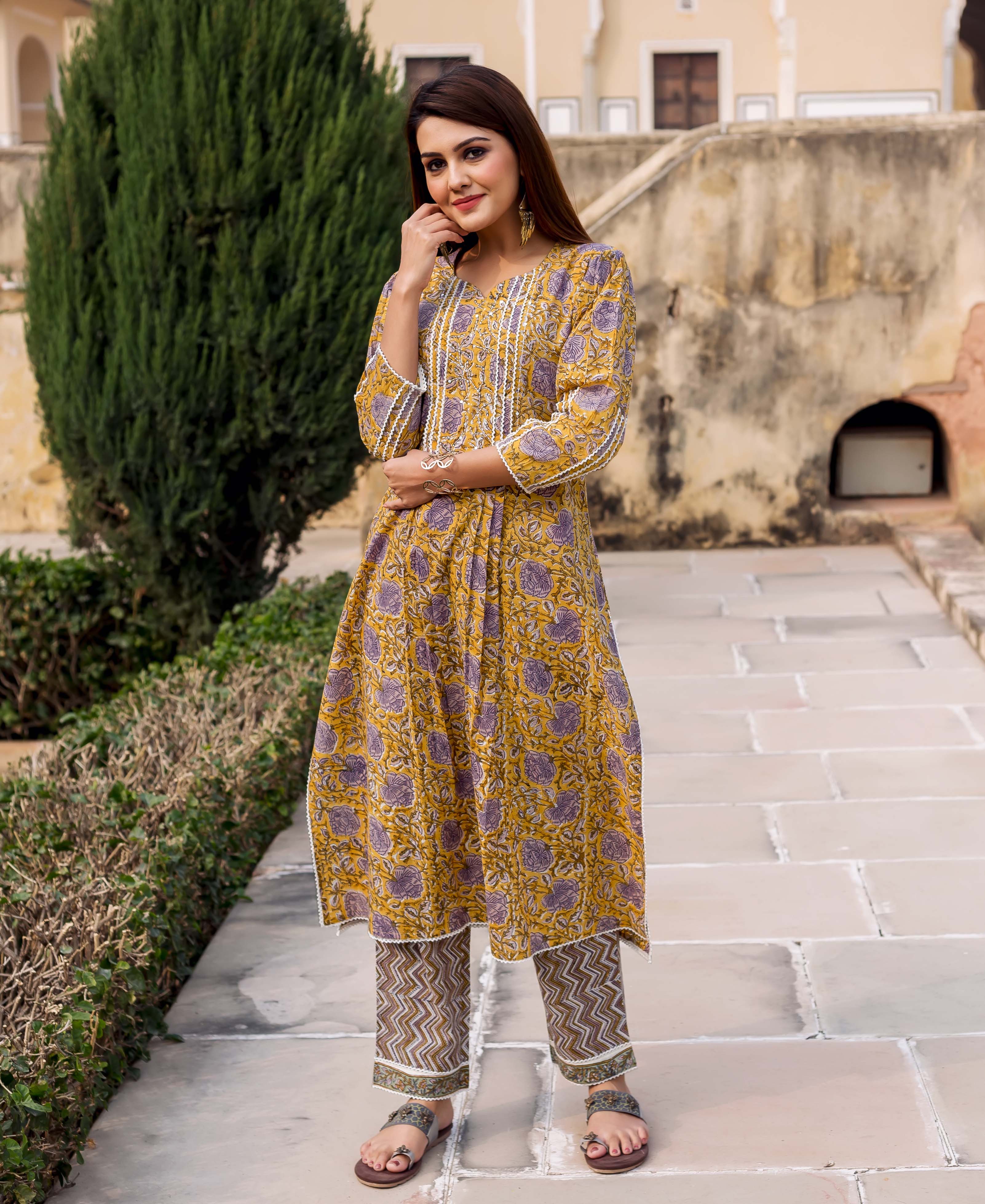 Front view model in yellow hand-block printed kurta with purple florals and patterned pants.
