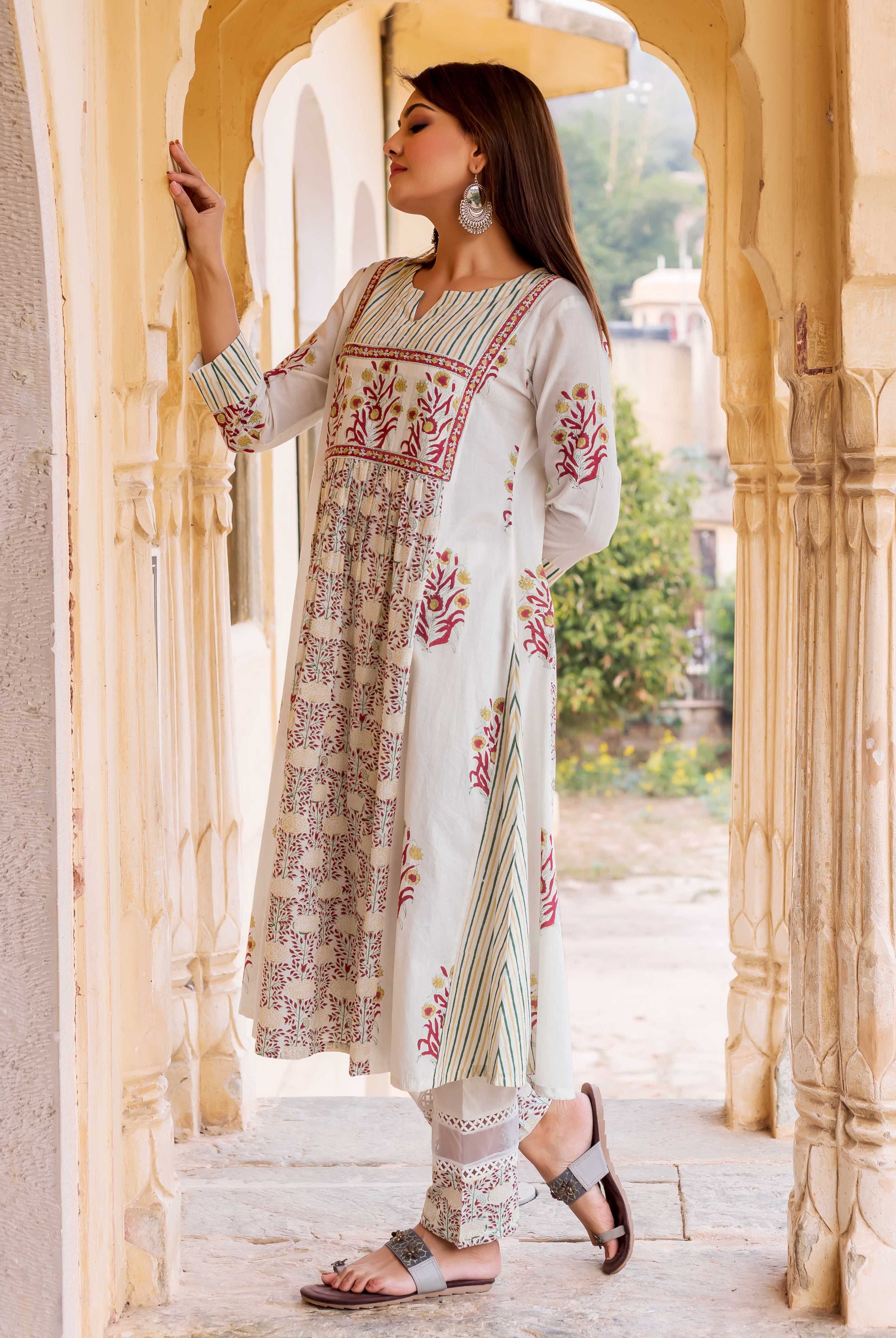 Model wears a white hand block printed Prisha Kurta set, red and yellow floral, green striped designs.
