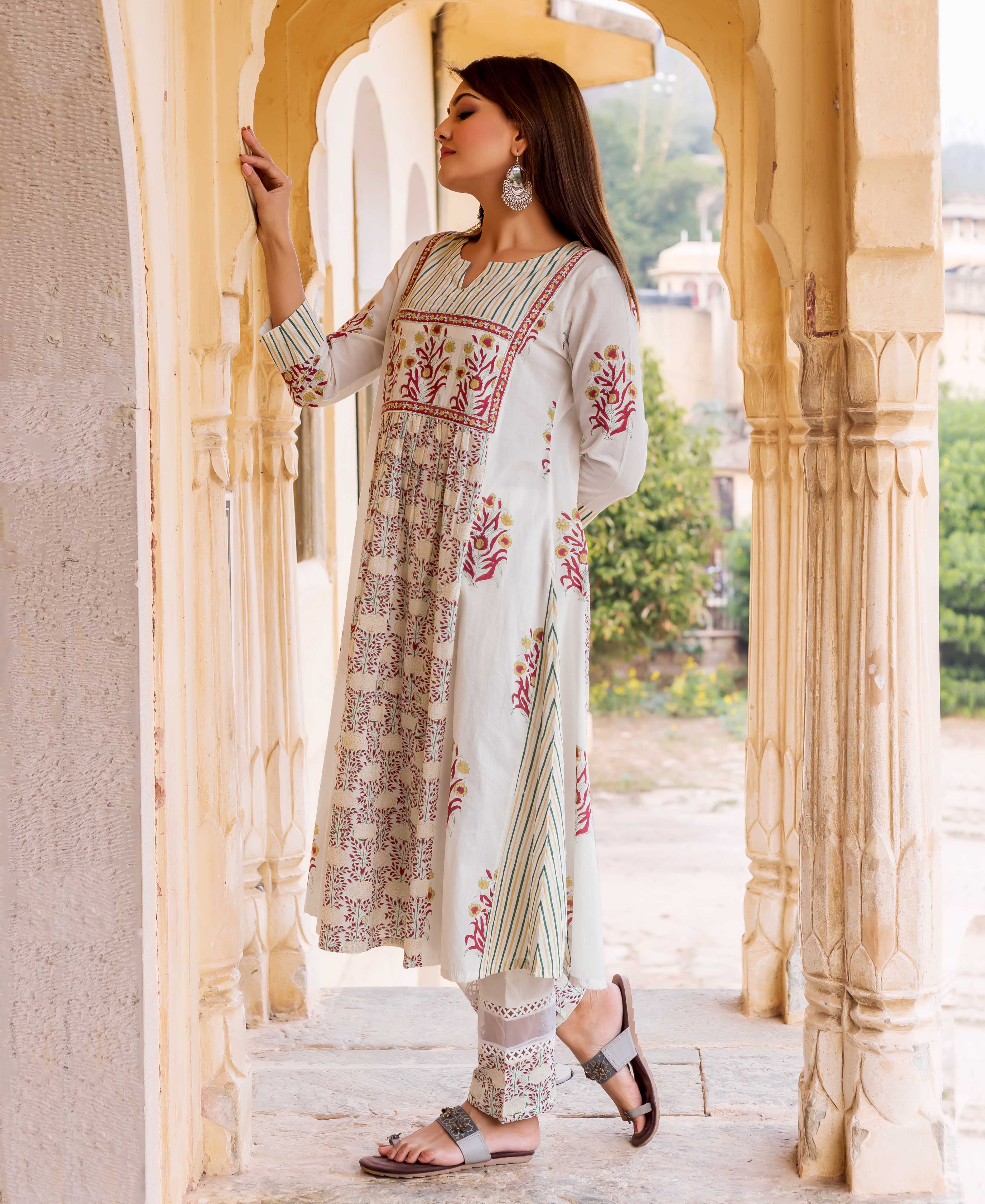 Model wears a white hand block printed Prisha Kurta set, red and yellow floral, green striped designs.