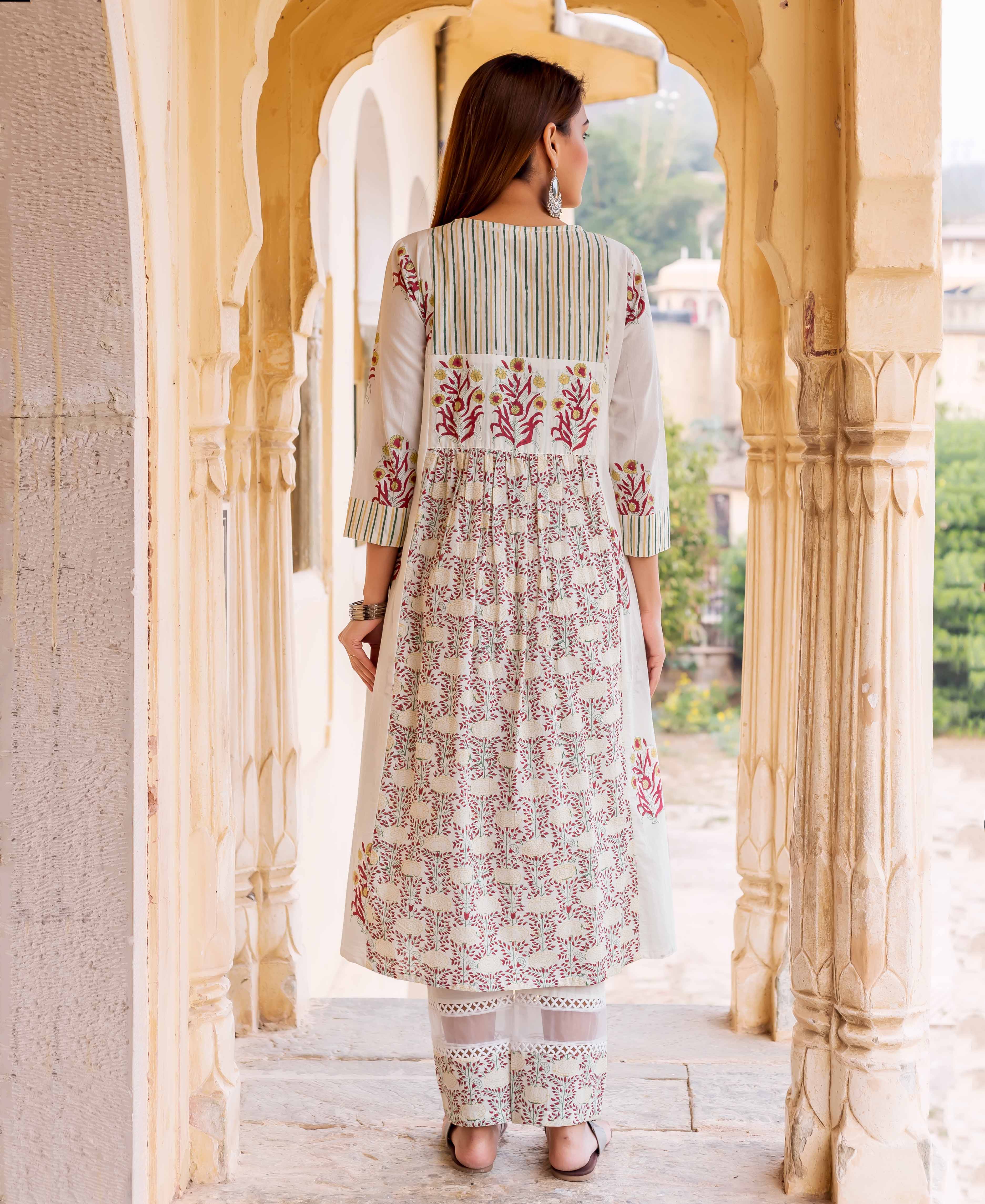 Back view of woman in off-white hand-block printed kurta set with floral and striped patterns.