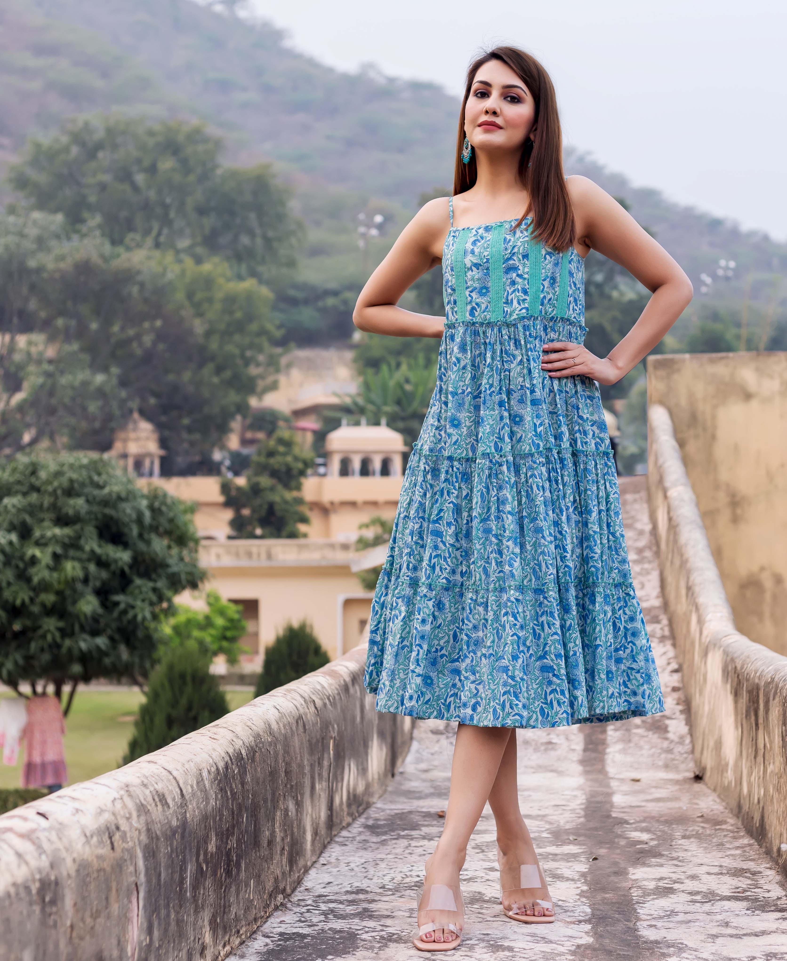 Model wears blue floral hand block printed tiered sundress with teal bodice, spaghetti straps.
