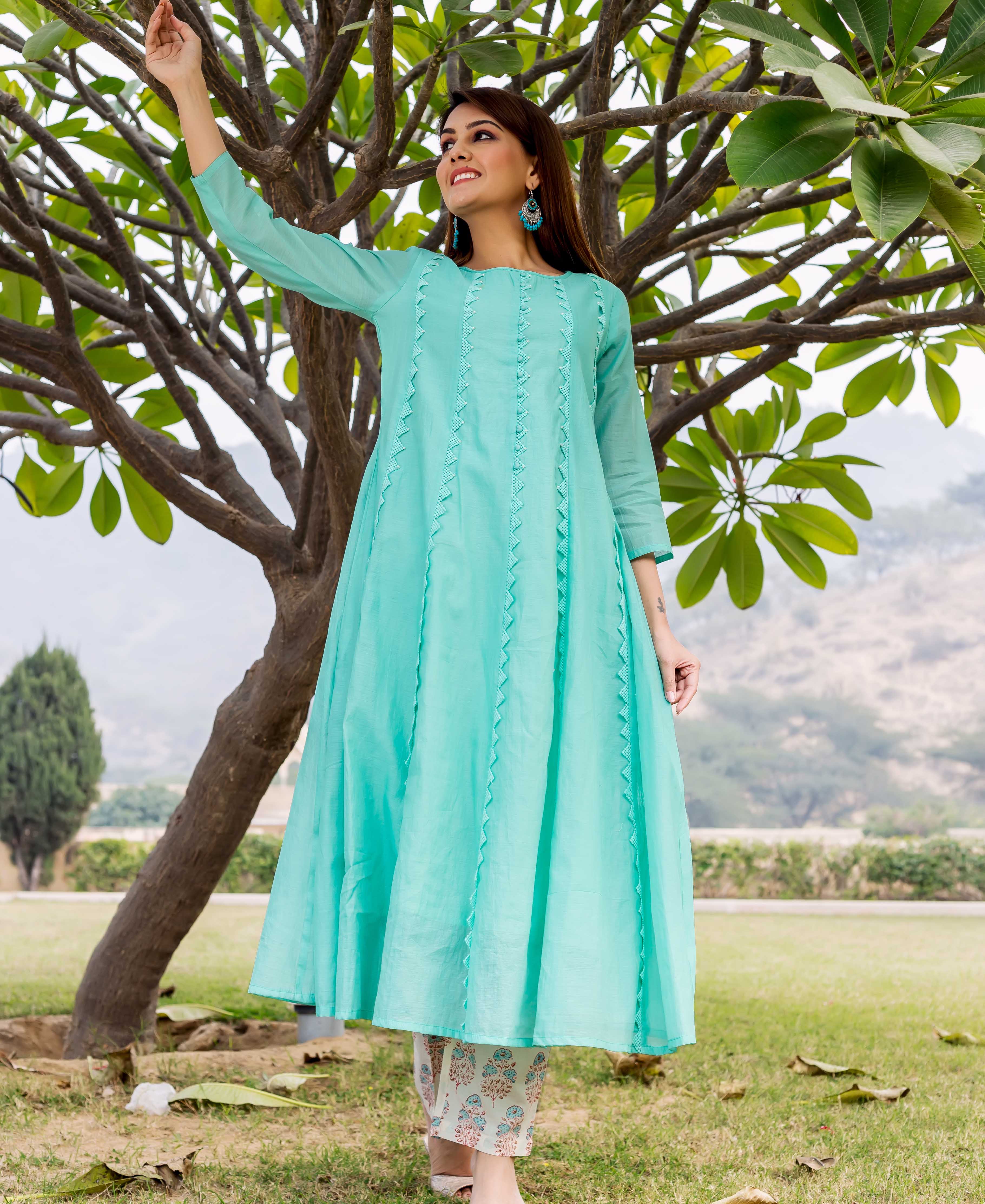 Full-length front view of a model in a sea green embroidered kurta with light block-printed bottoms.