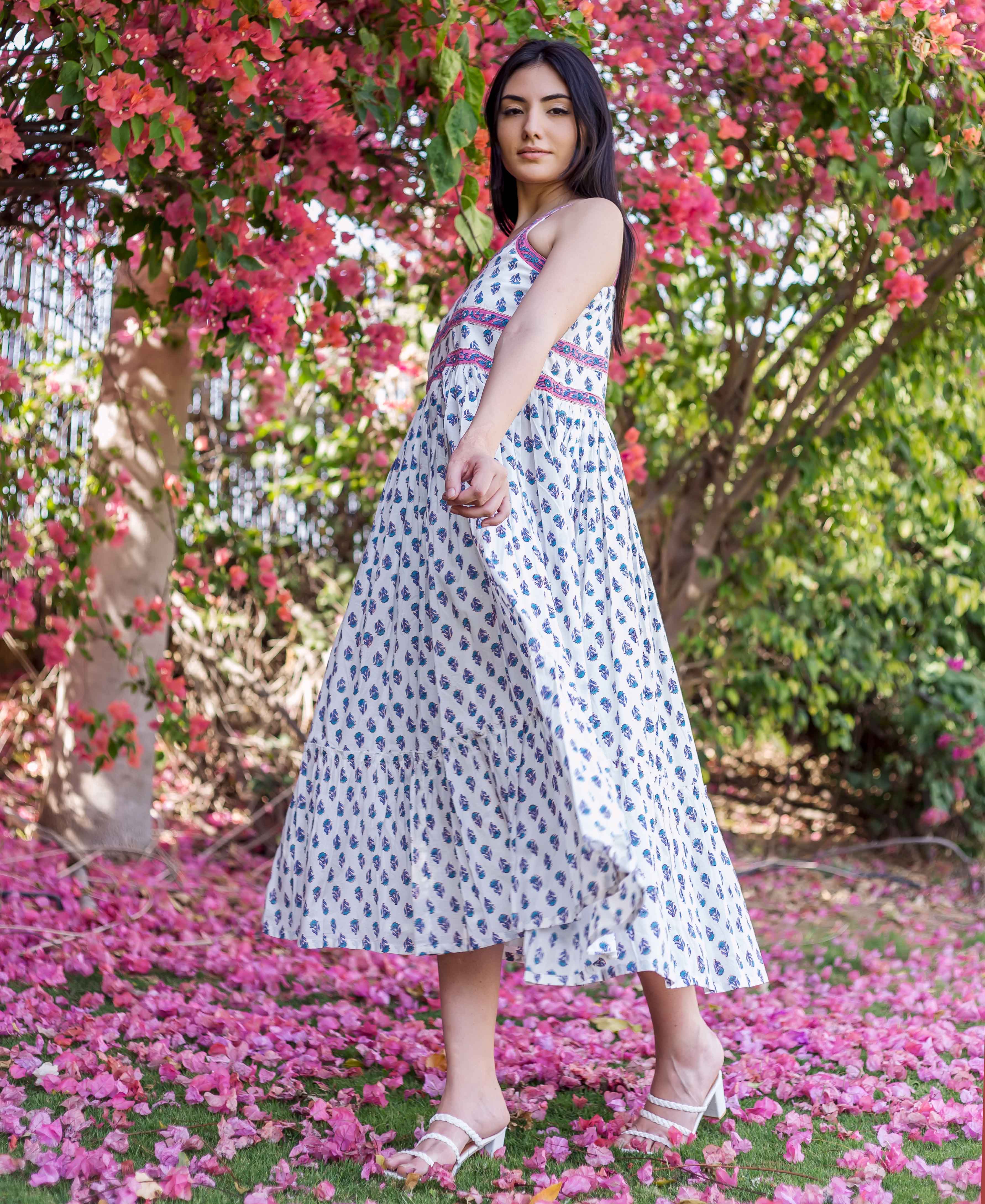 Model in white hand-block printed maxi dress with blue motifs and pink trim.