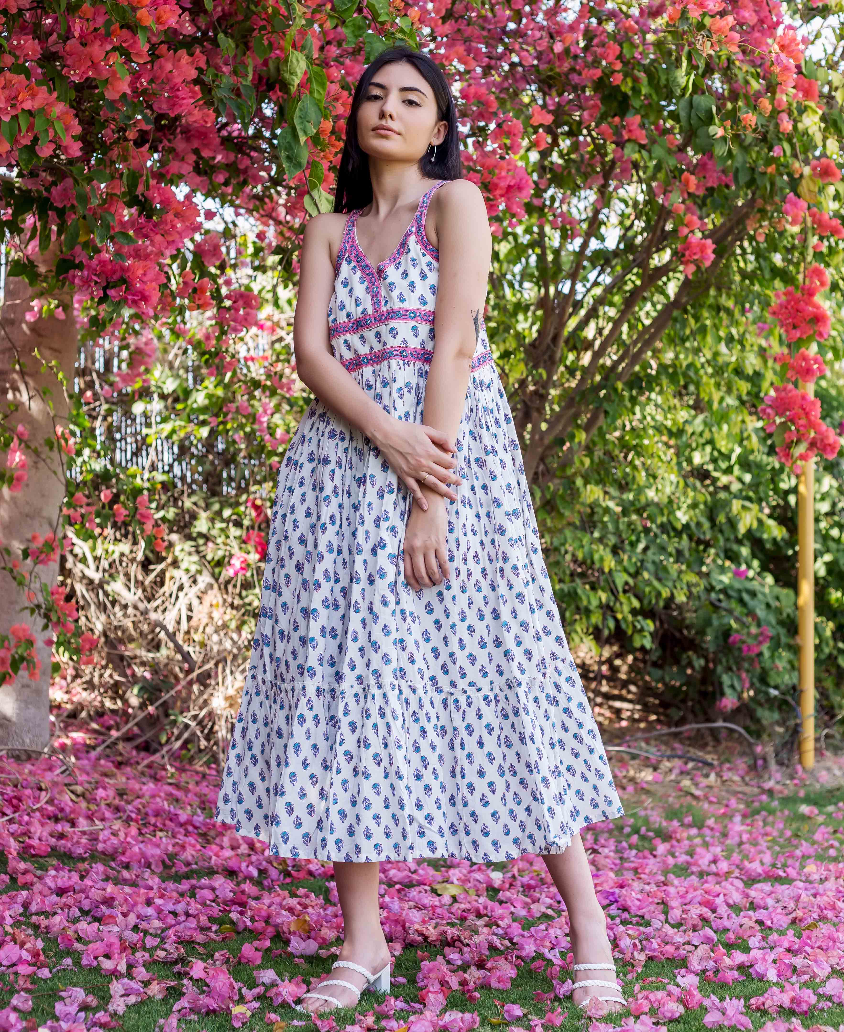 Model wearing a white tiered midi dress with blue, purple block print, pink bodice.