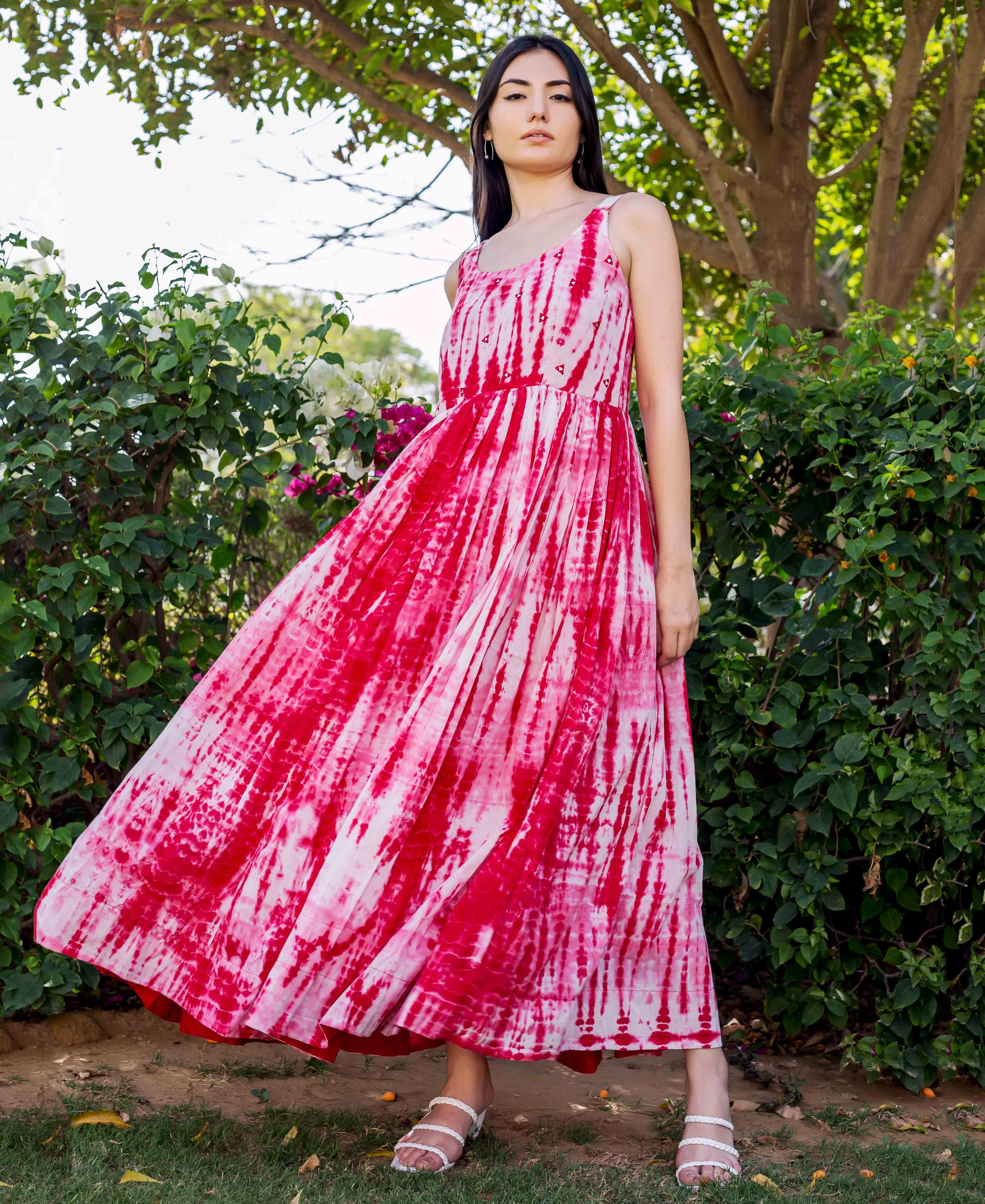 Model in a vibrant red and white tie-dye embroidered sleeveless maxi dress.