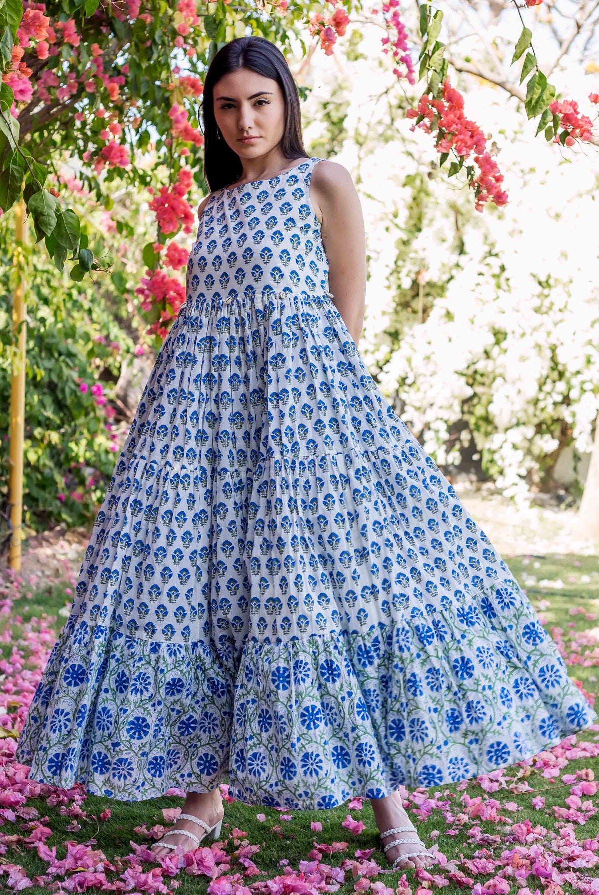 Model in white and blue hand-block-printed tiered ethnic maxi dress standing in a garden.