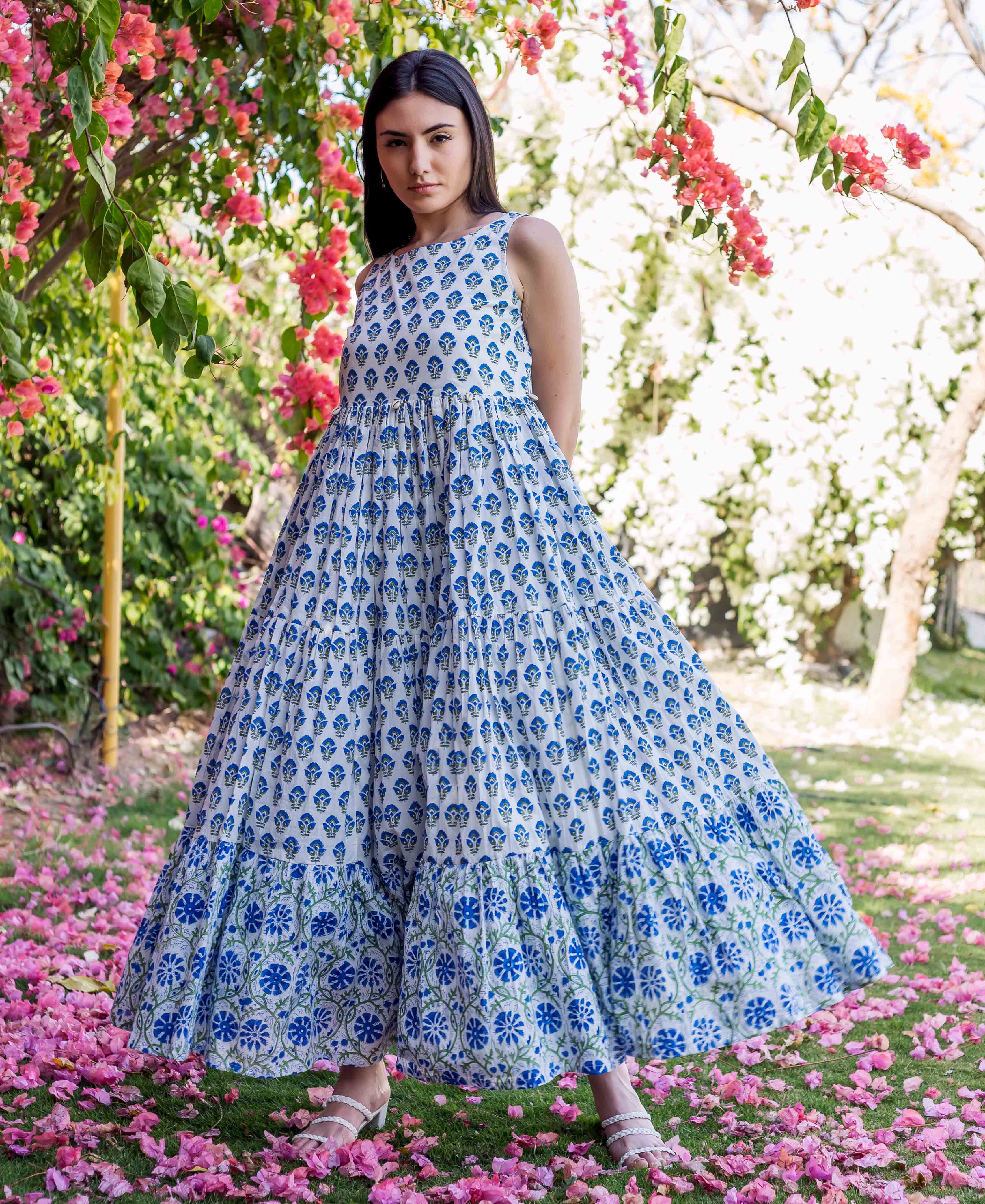 Model in white and blue hand-block-printed tiered ethnic maxi dress standing in a garden.