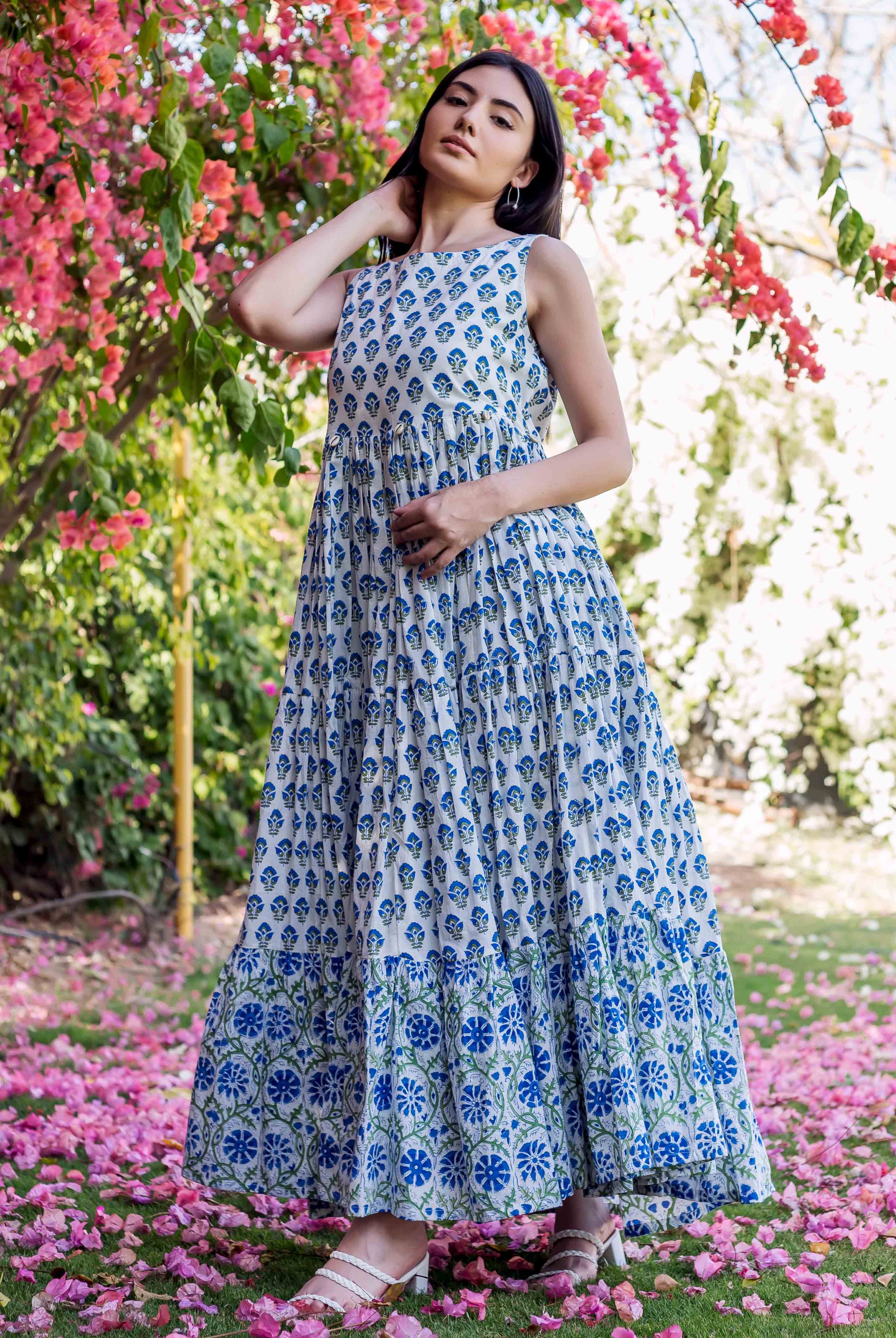 Full-length model in white and blue hand-block-printed tiered maxi dress with floral motifs.