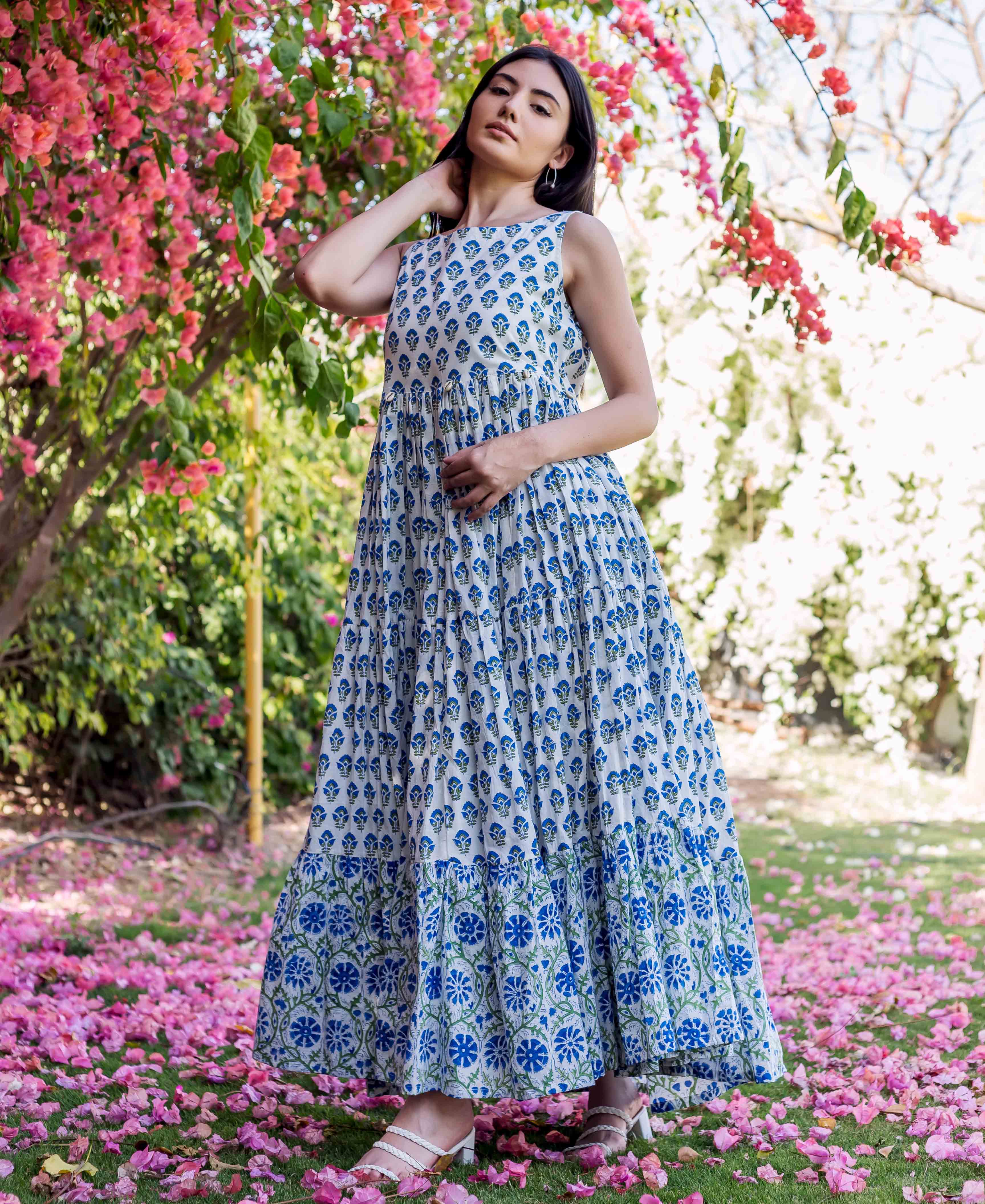 Full-length model in white and blue hand-block-printed tiered maxi dress with floral motifs.