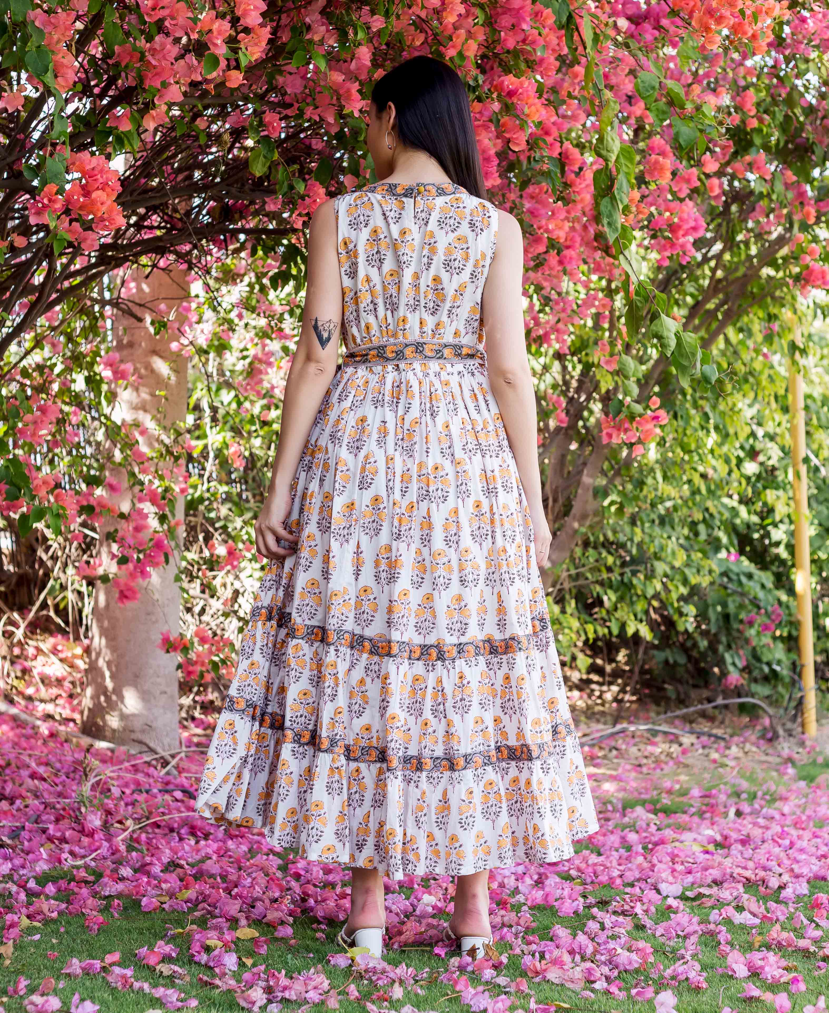 Back view of model wearing a white, yellow, and grey block print tiered maxi dress.