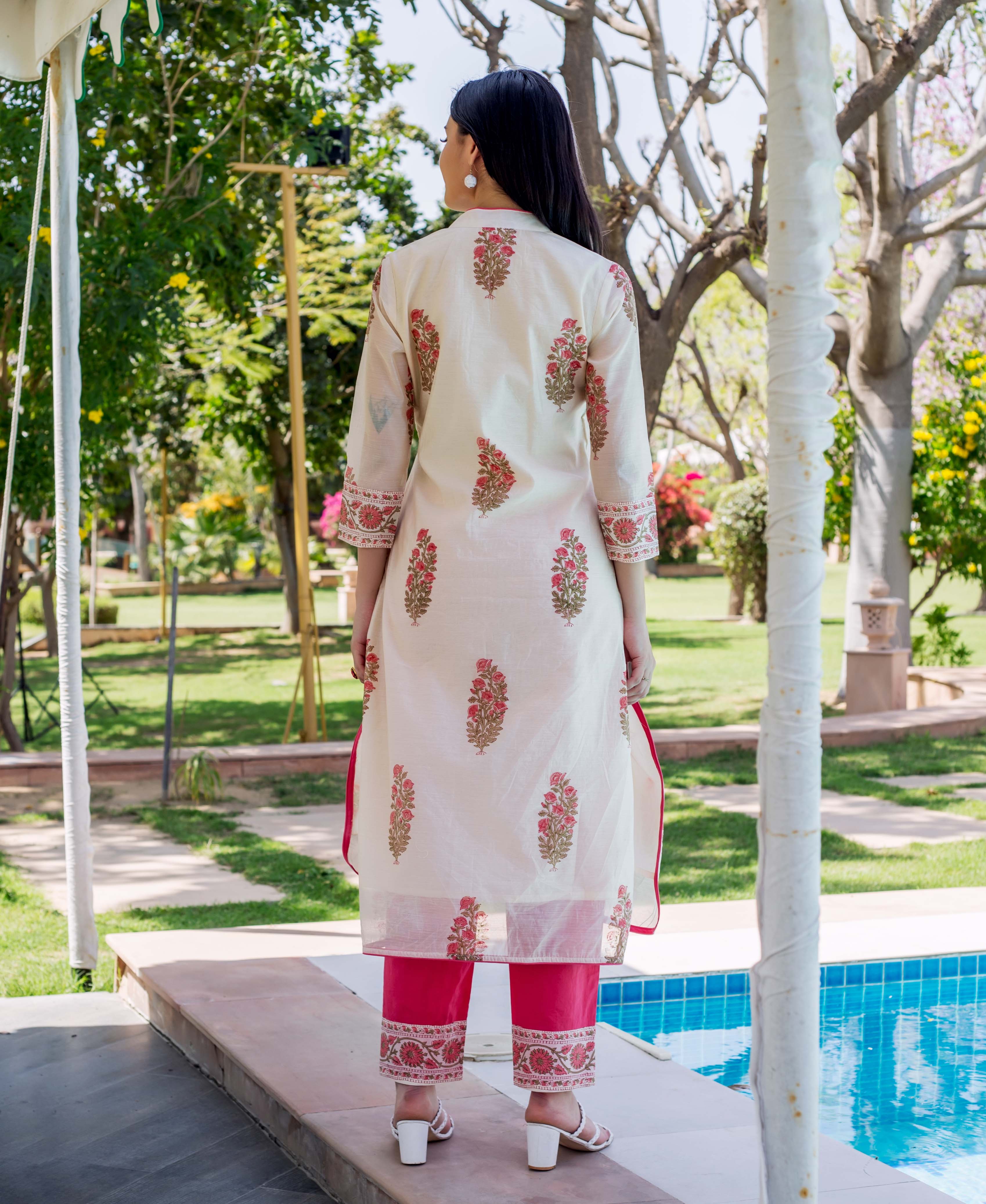 Back view of model in cream floral hand-block-printed kurta and hot pink pants.