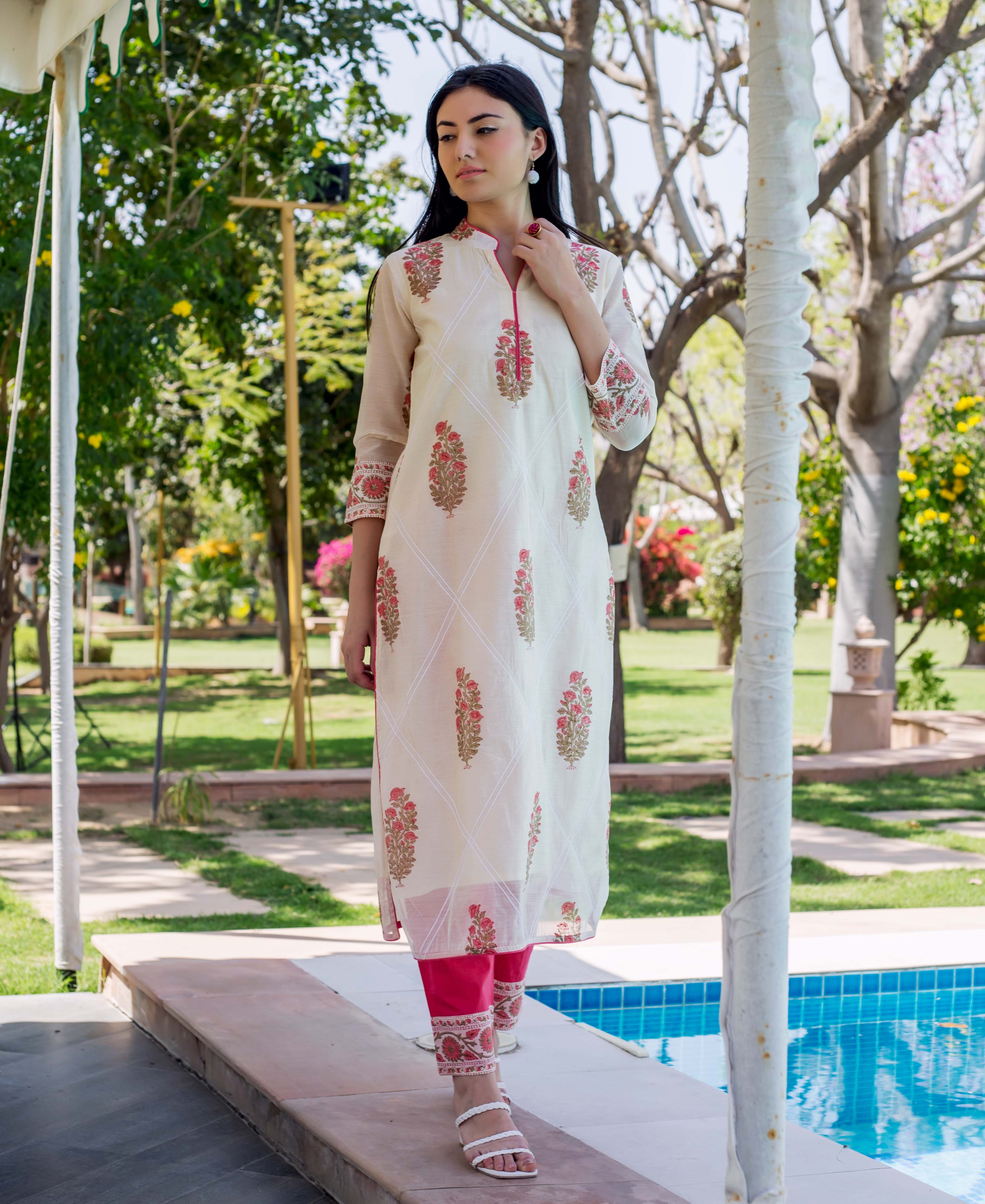 Model wears cream straight kurta with red hand-block-prints and pink pants.