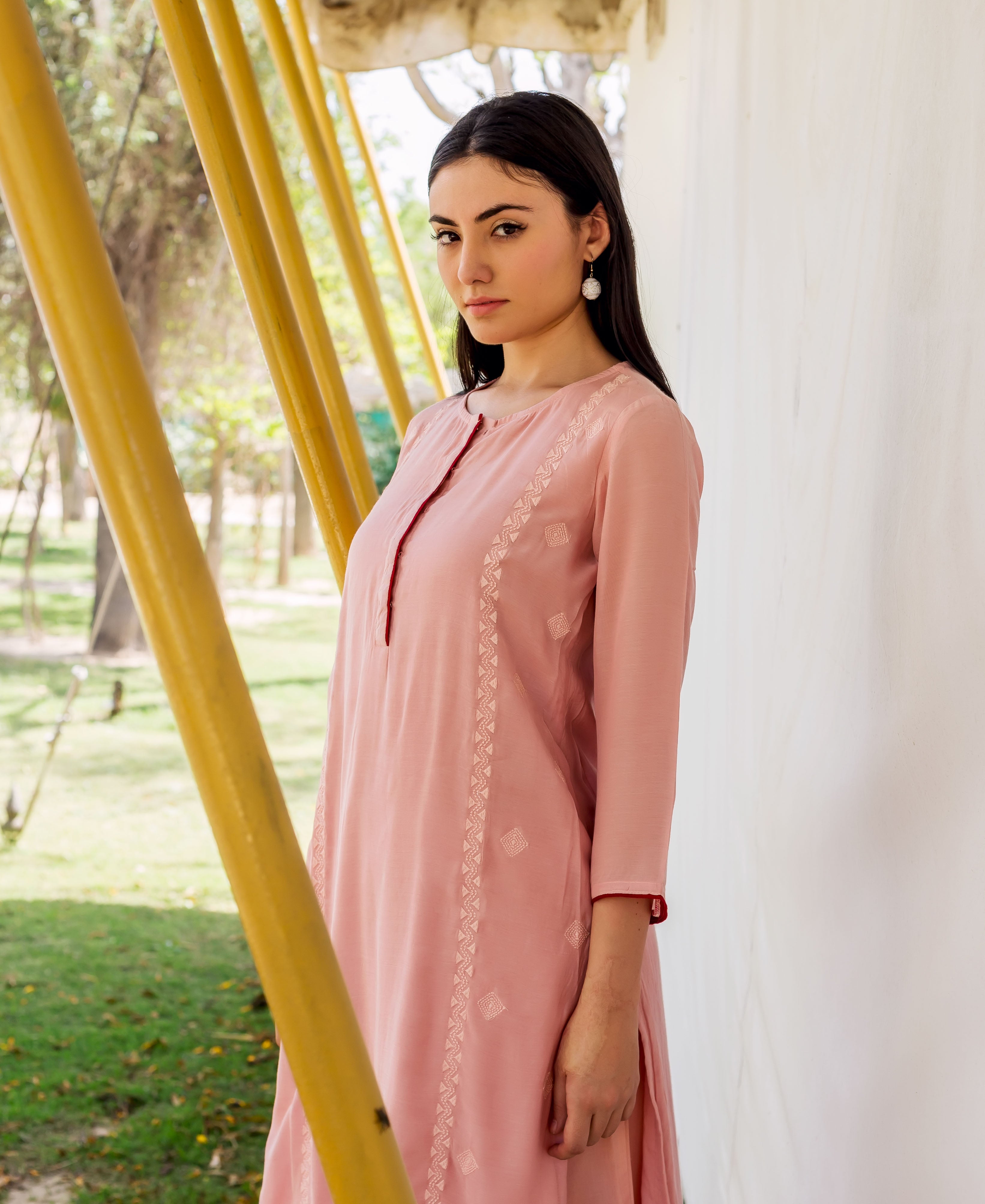 Dusty pink embroidered straight kurta on model, featuring subtle white geometric patterns.