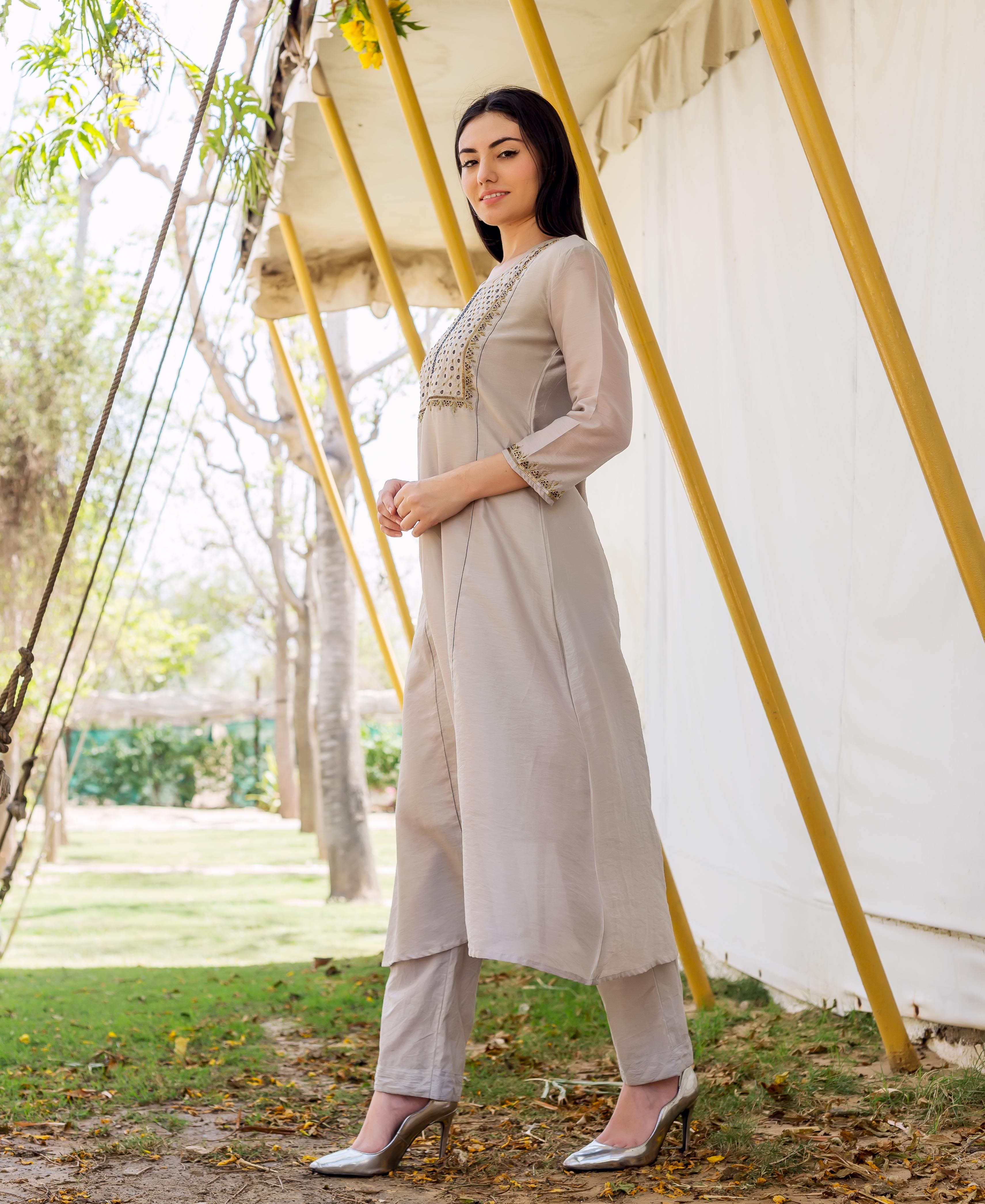 Side view of model wearing an elegant grey embroidered kurta set with matching pants.