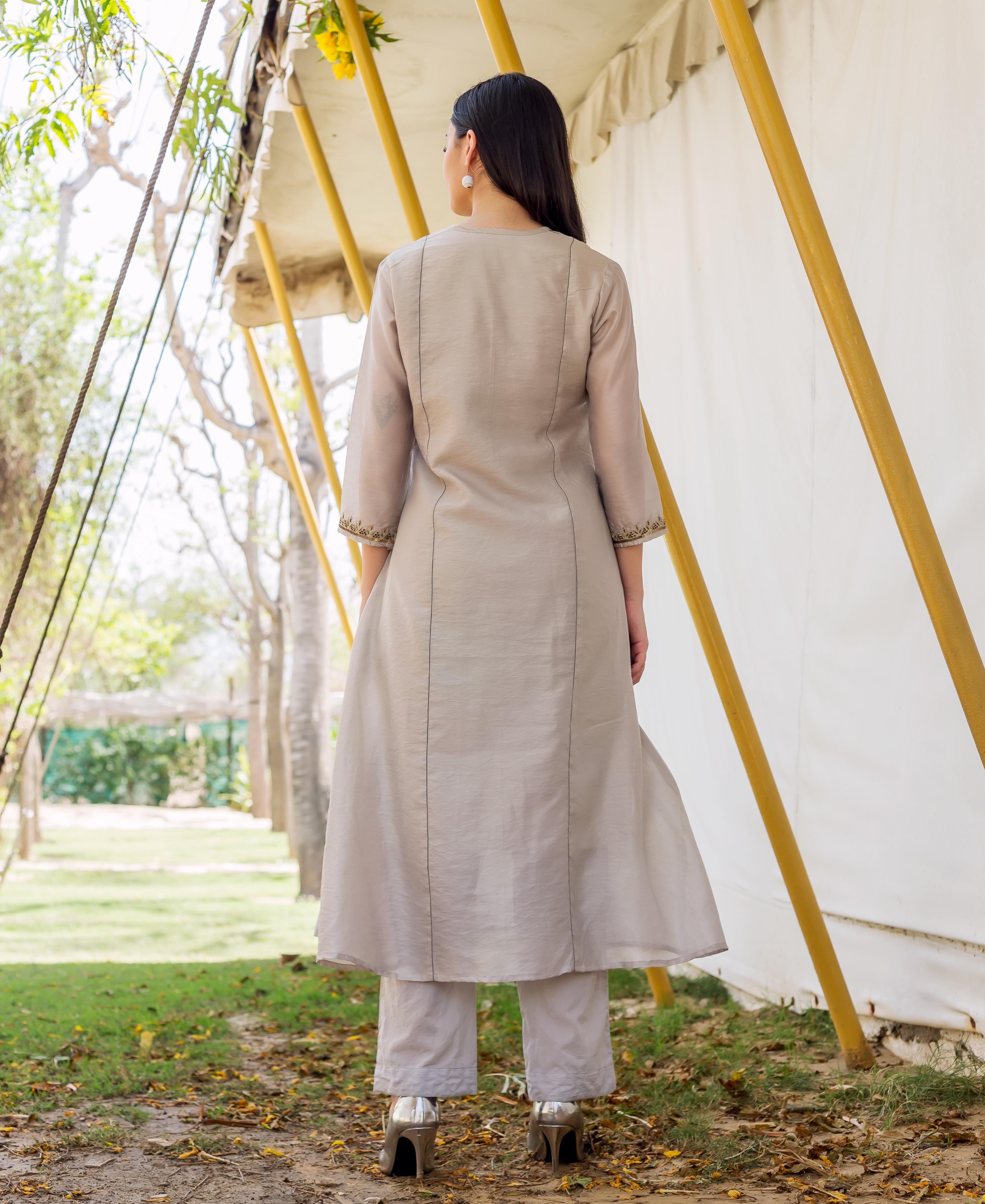 Back view of model in grey embroidered kurta and matching trousers.