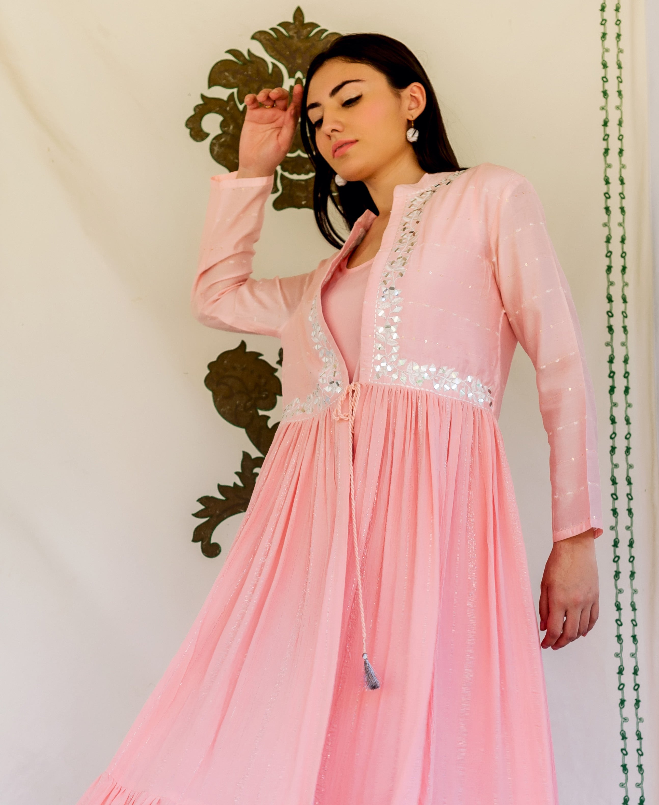 Front view of model wearing a flamingo pink embroidered kurta with mirror work.