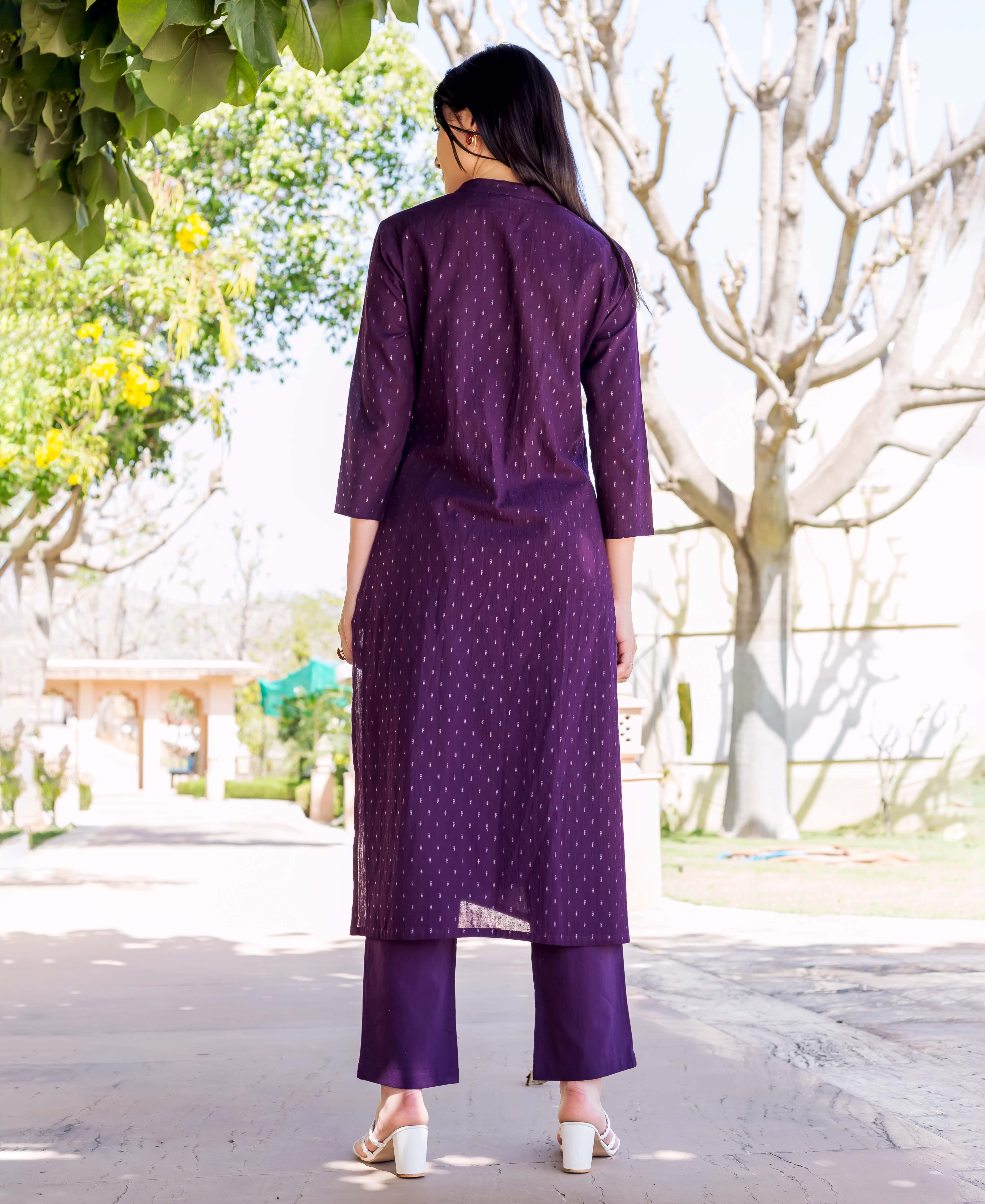 Purple kurta with gold dots and straight pants on a woman outdoors, back view.