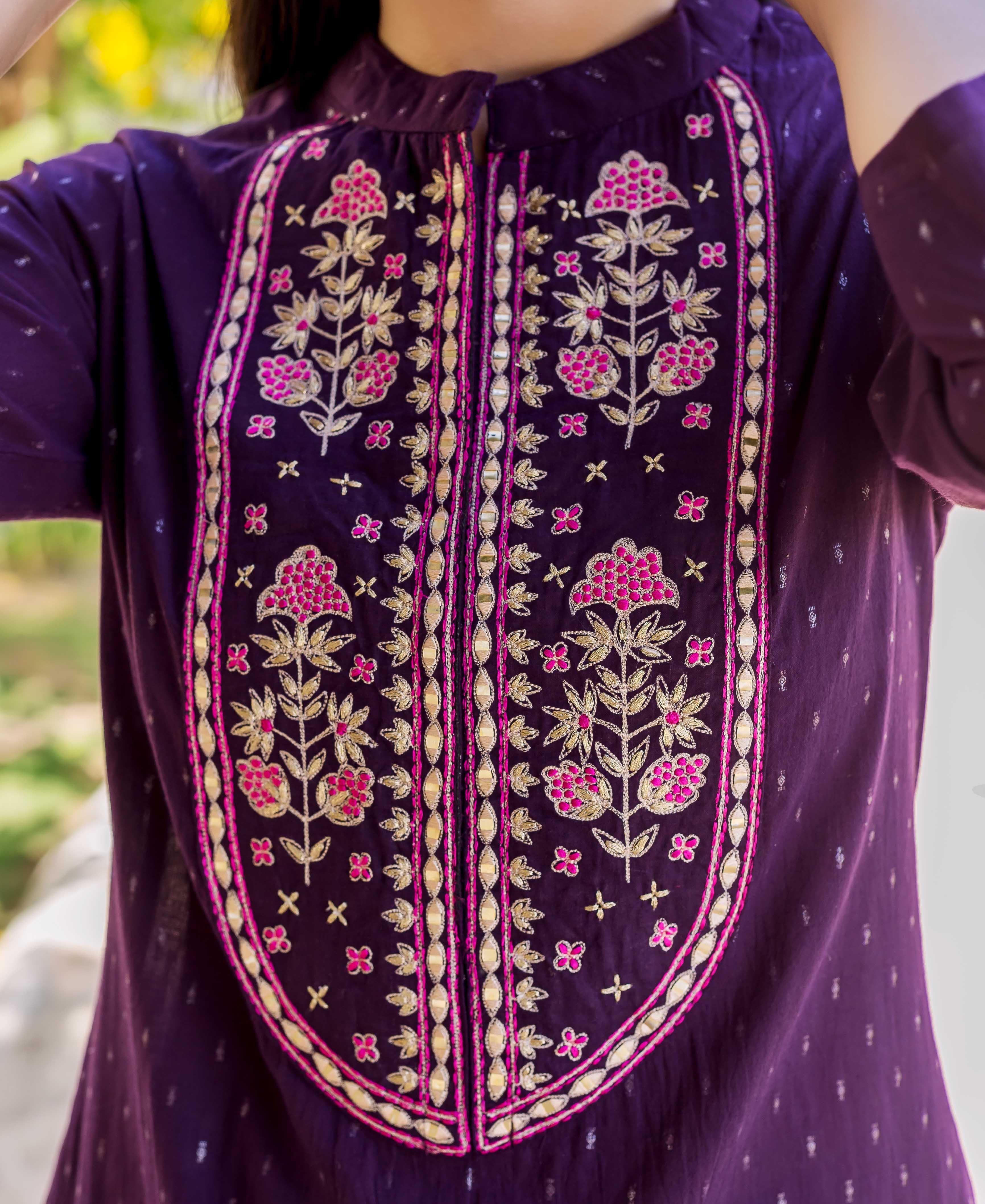 Close-up of wine purple lurex kurta with gold and pink floral embroidered placket.
