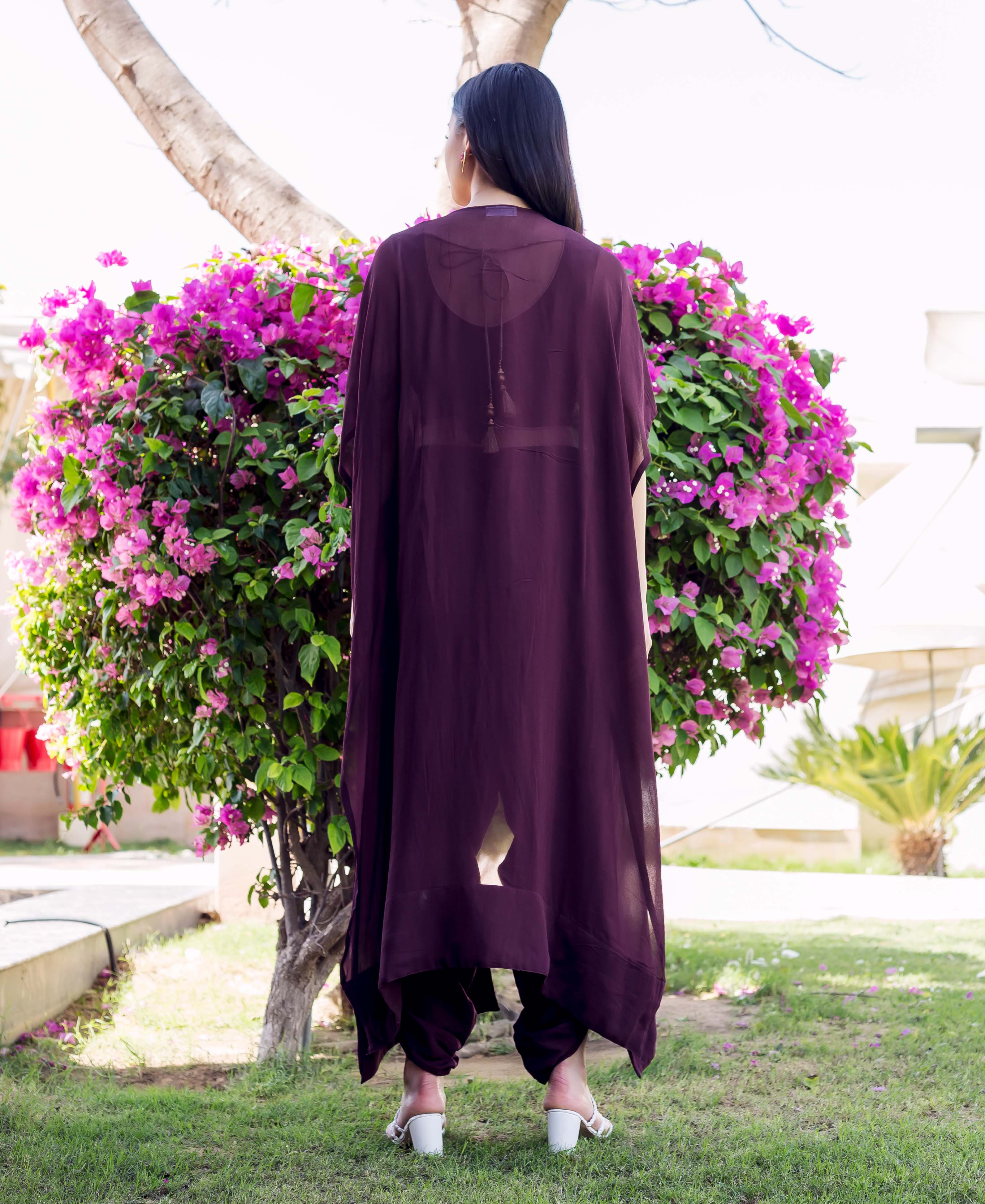 Rear view of model in wine sheer jacket with dori tassel and matching dhoti pants.