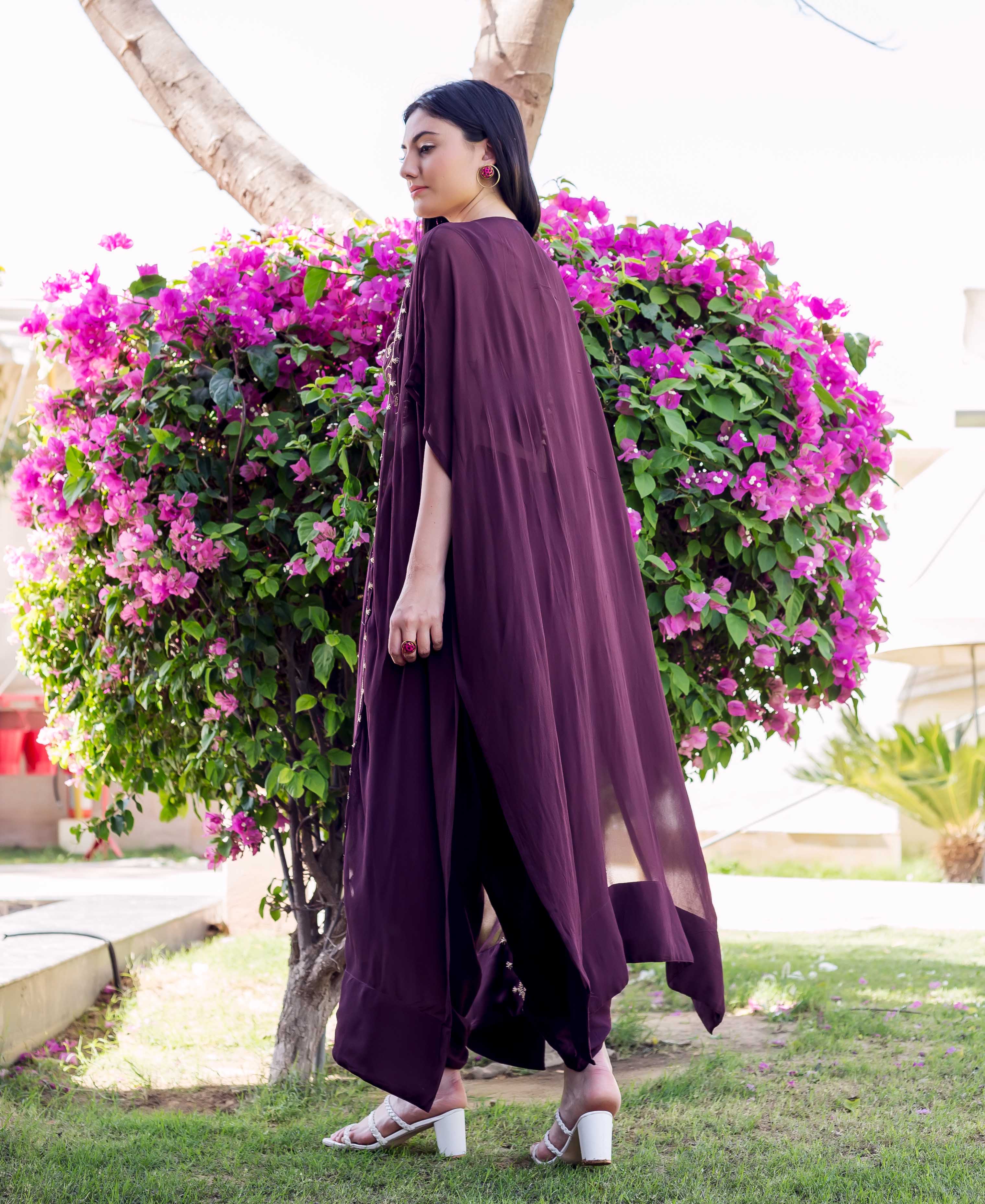 Woman wearing a wine flowy long embroidered jacket and dhoti pants set.