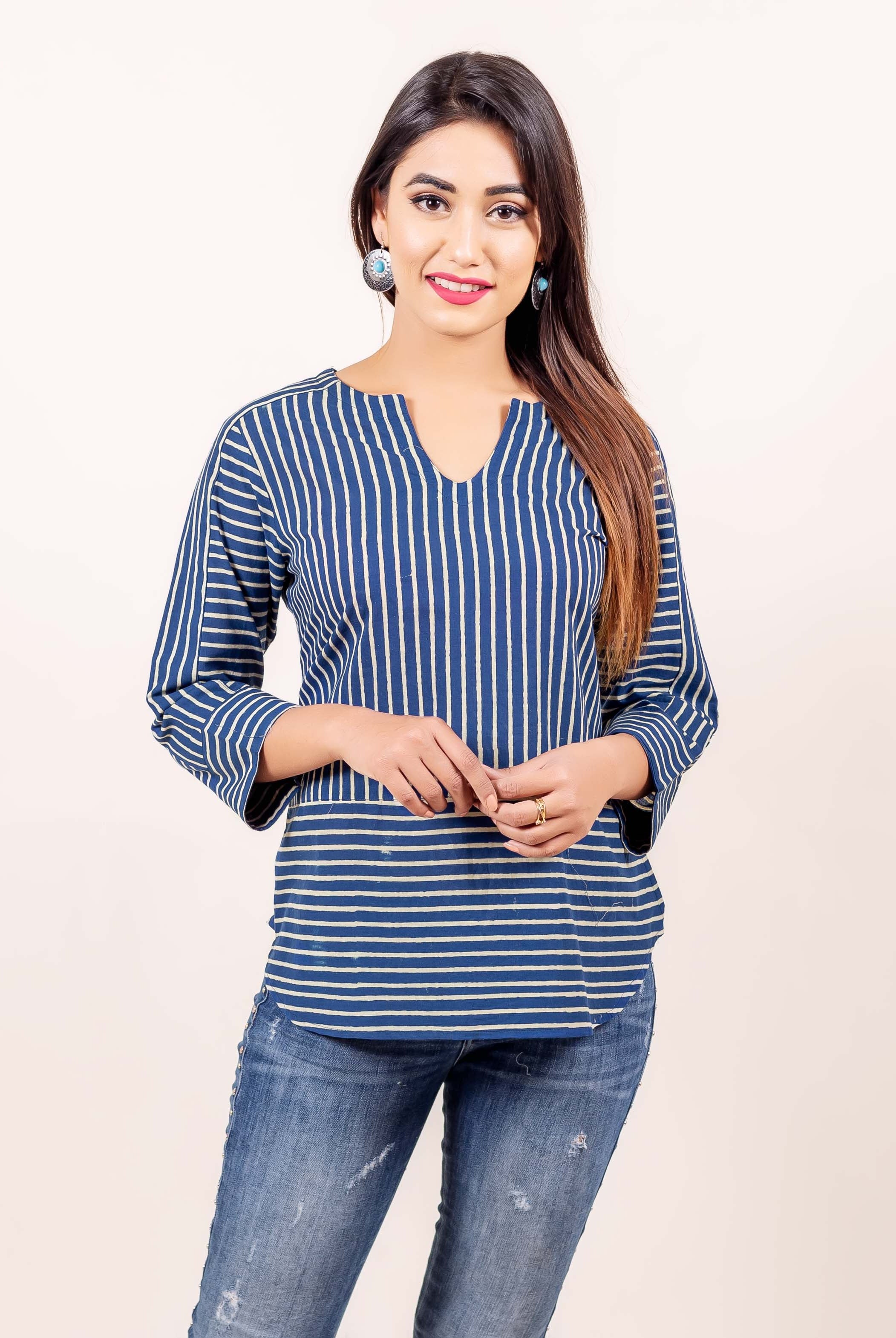 A model wearing a blue and white striped top with a V-neckline.