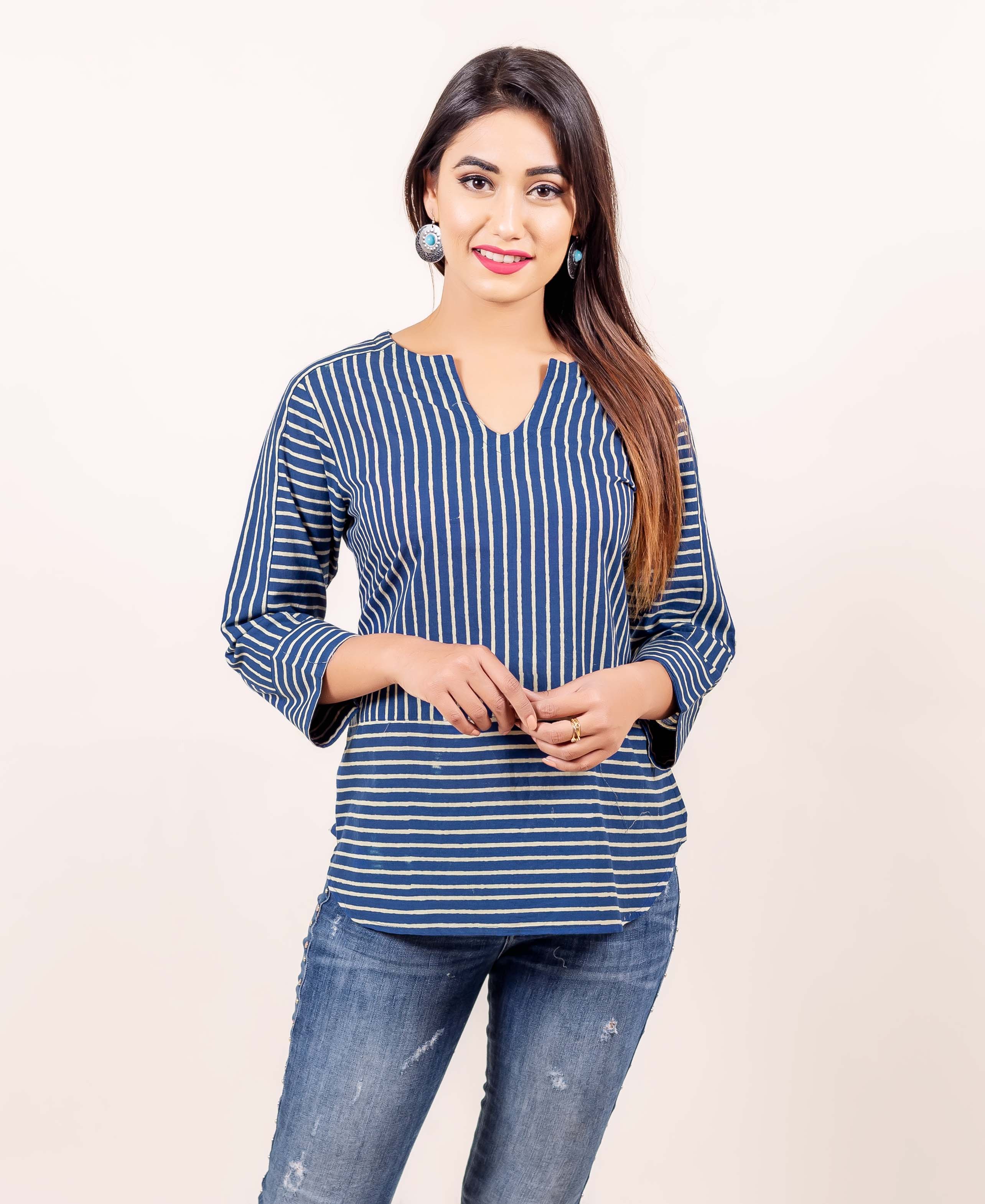 A model wearing a blue and white striped top with a V-neckline.
