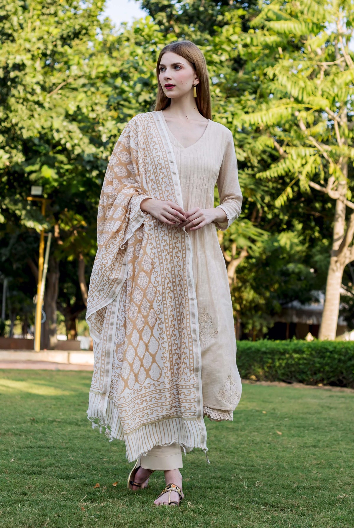 Model wearing an embroidered beige kurta and hand-block-printed cream and brown dupatta.