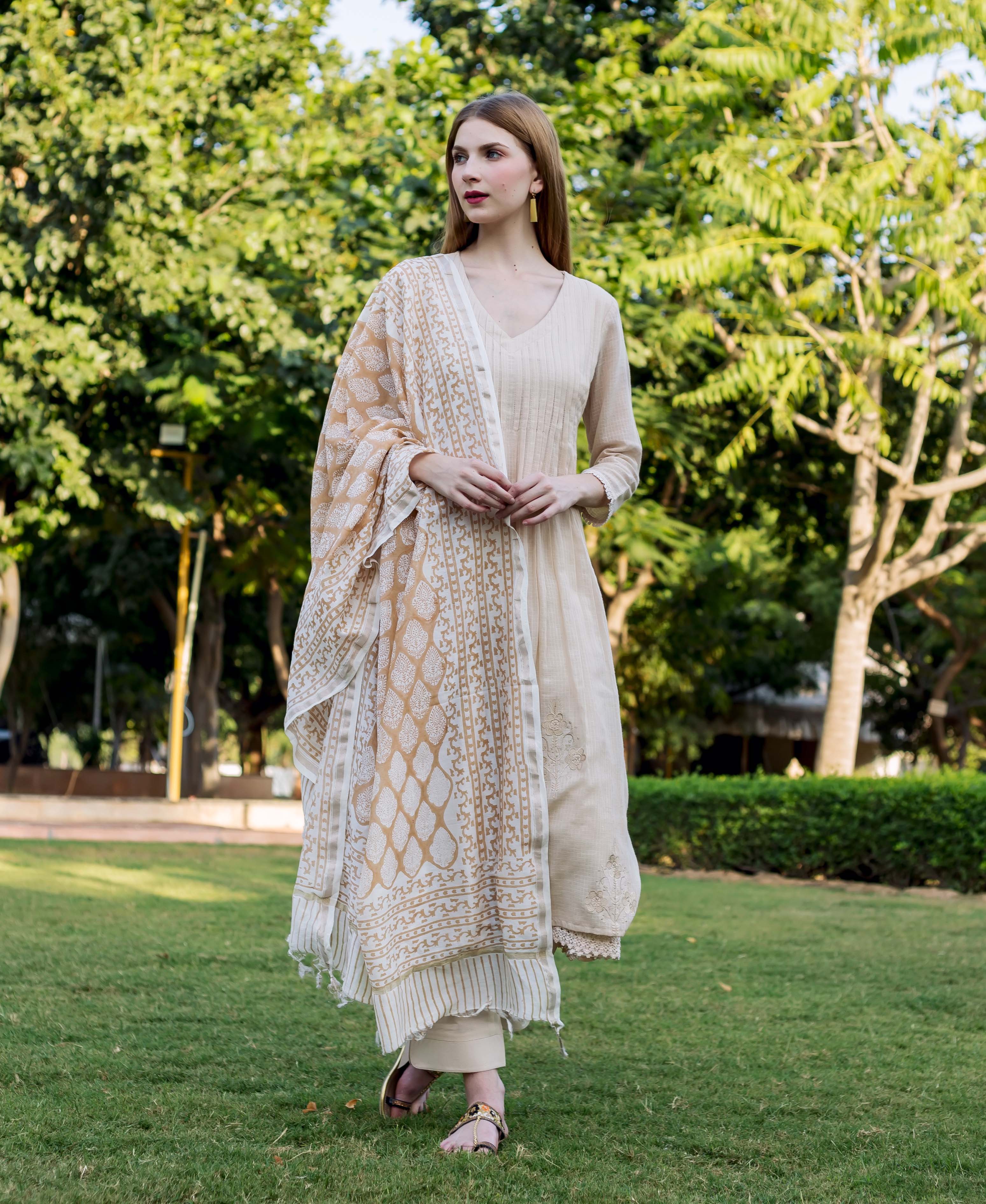 Model wearing an embroidered beige kurta and hand-block-printed cream and brown dupatta.