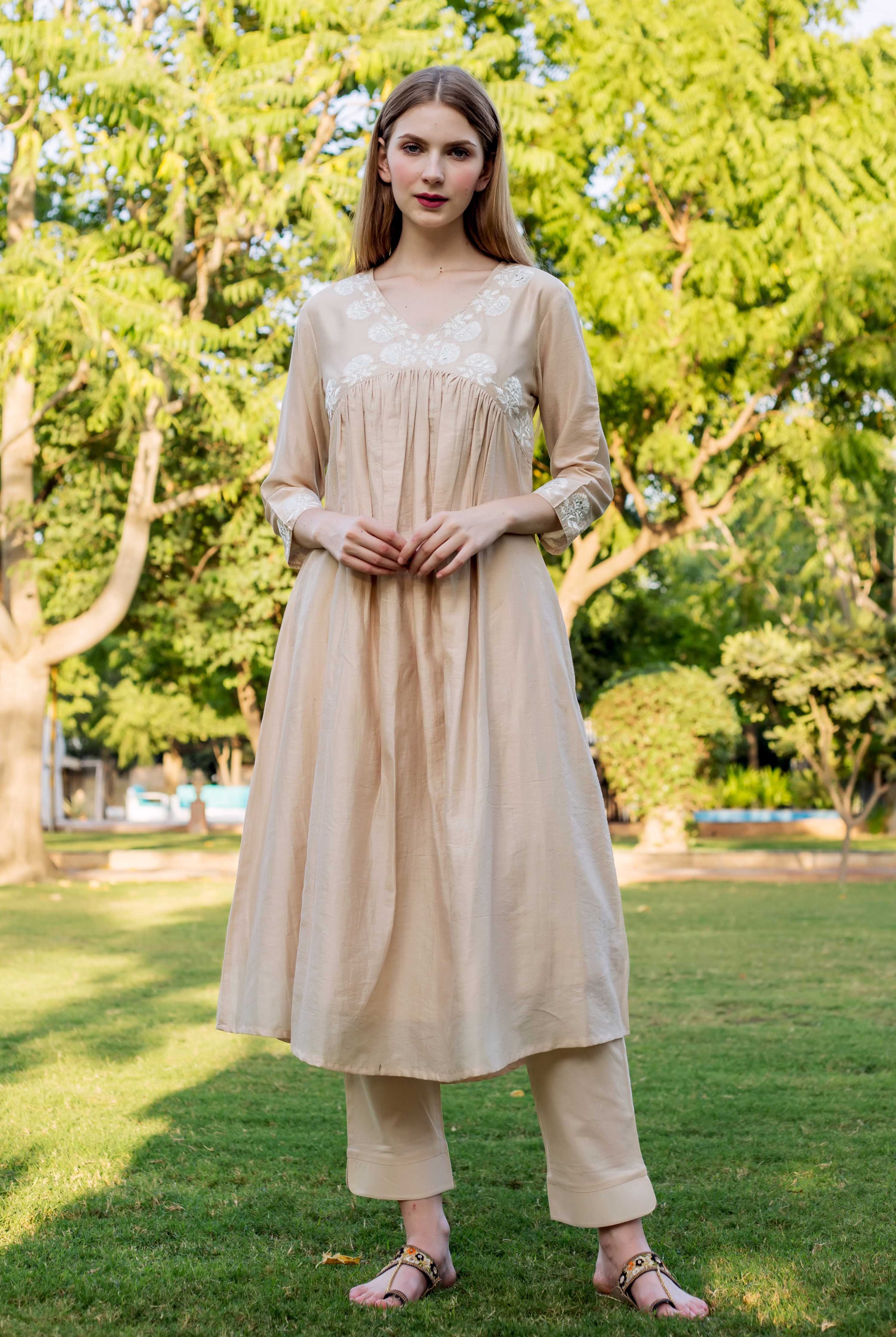 Full front view of model in beige chanderi kurta with white yoke embroidery and pants.
