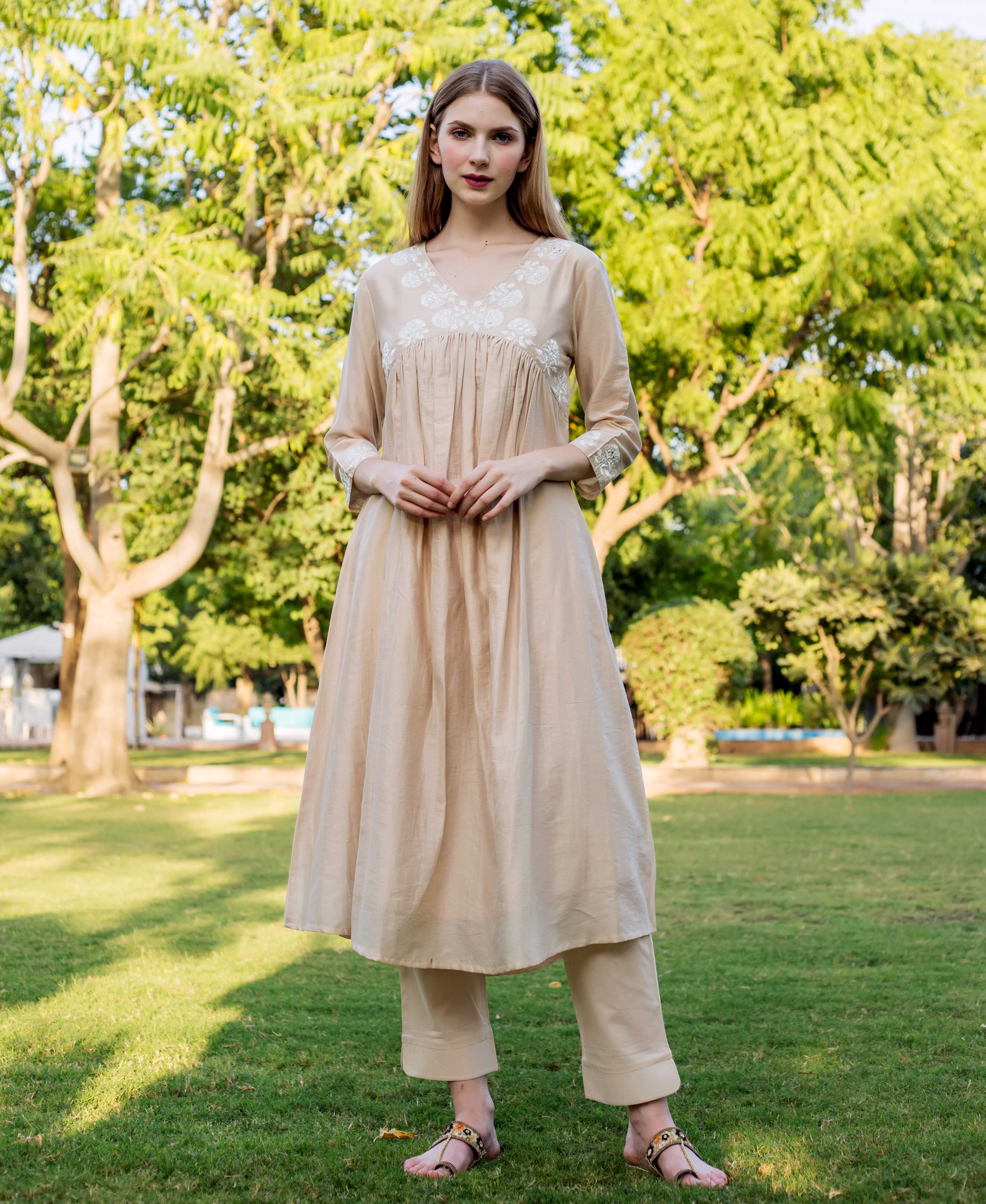 Full front view of model in beige chanderi kurta with white yoke embroidery and pants.