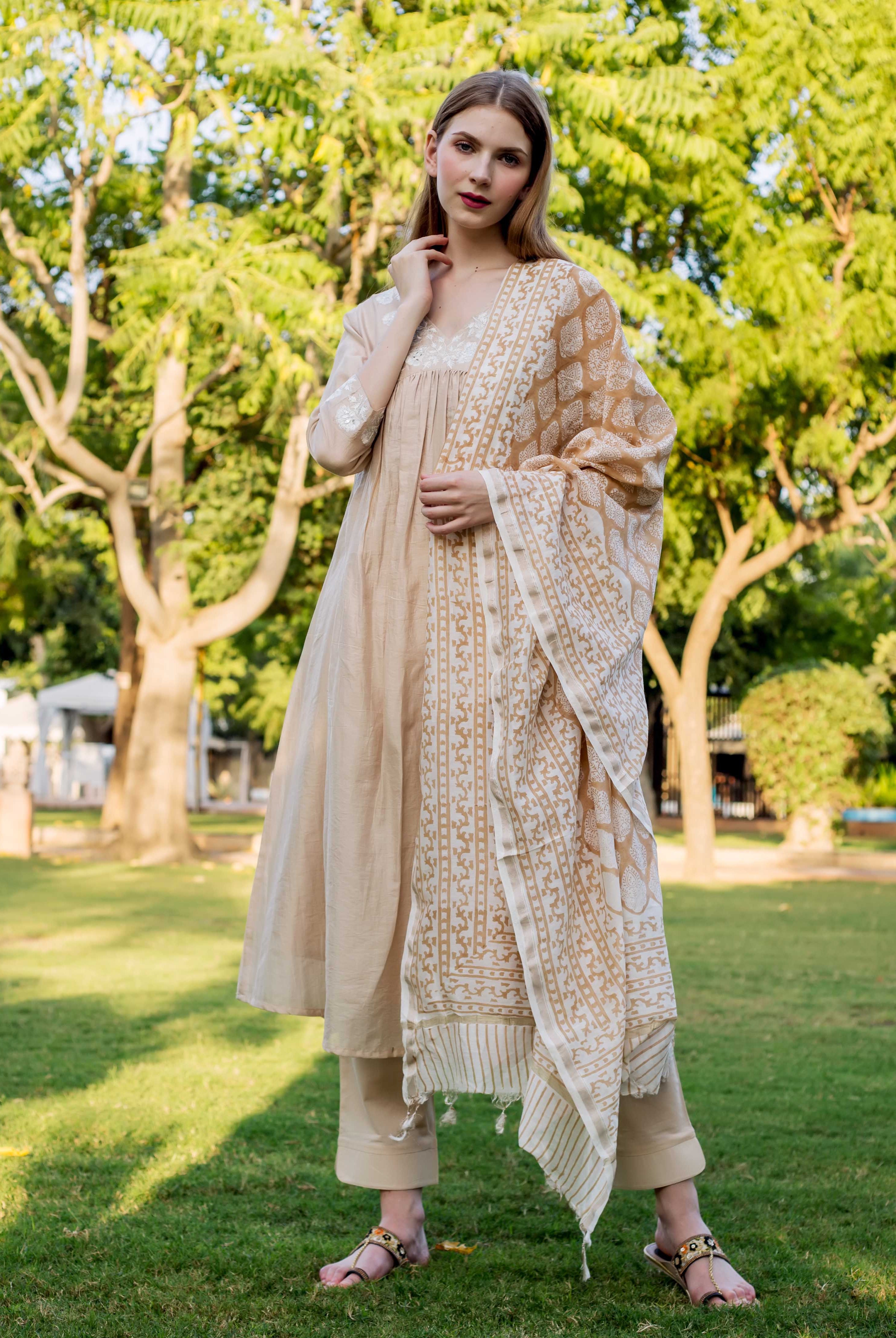 A model wearing a beige chanderi kurta with white embroidery and a matching dupatta.